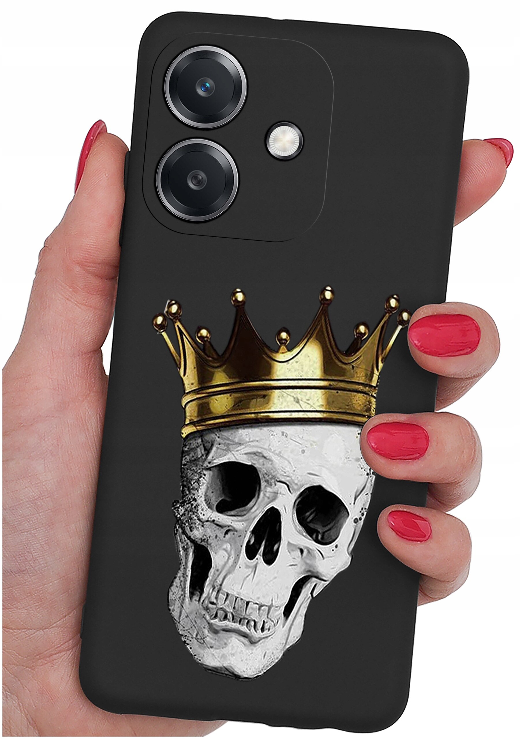 Czarna obudowa telefonu z nadrukiem czaszki w złotej koronie, trzymana w dłoni z czerwonymi paznokciami. Widoczne są dwa obiektywy aparatu i lampa błyskowa.