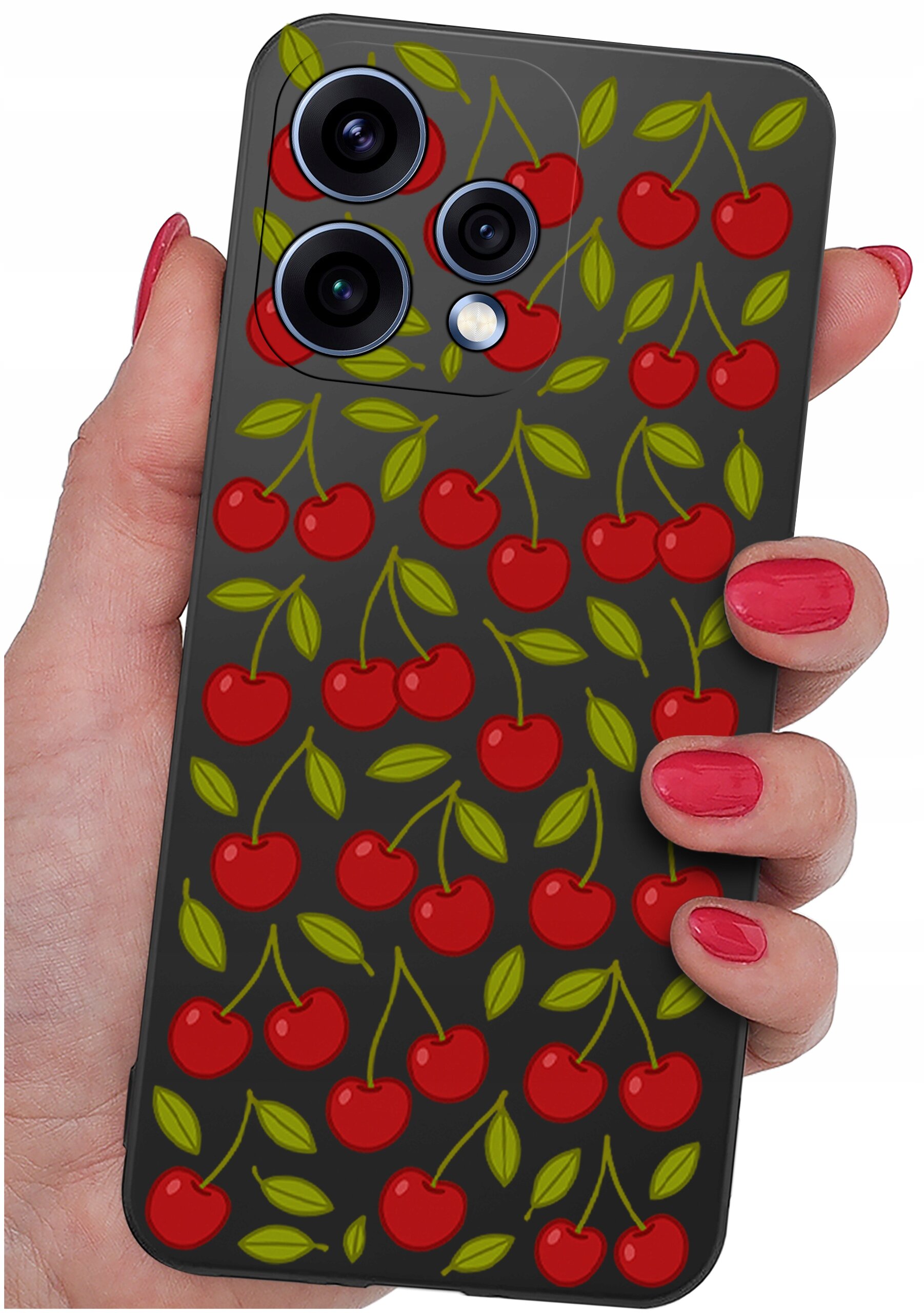 Etui na telefon z wzorem czerwonych wiśni i zielonych liści na ciemnym tle, trzymane w dłoni z pomalowanymi na czerwono paznokciami. Widoczne są trzy obiektywy aparatu telefonu.
