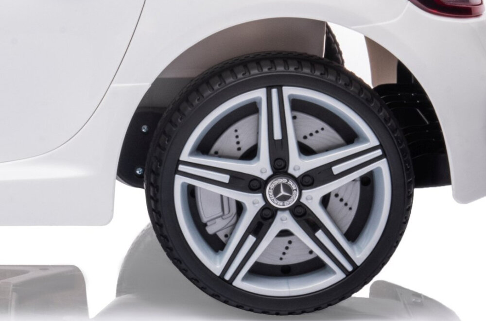 Zdjęcie przedstawia koło samochodu dziecięcego z widocznym logo Mercedes-Benz na środku felgi. Samochód jest w kolorze białym.
