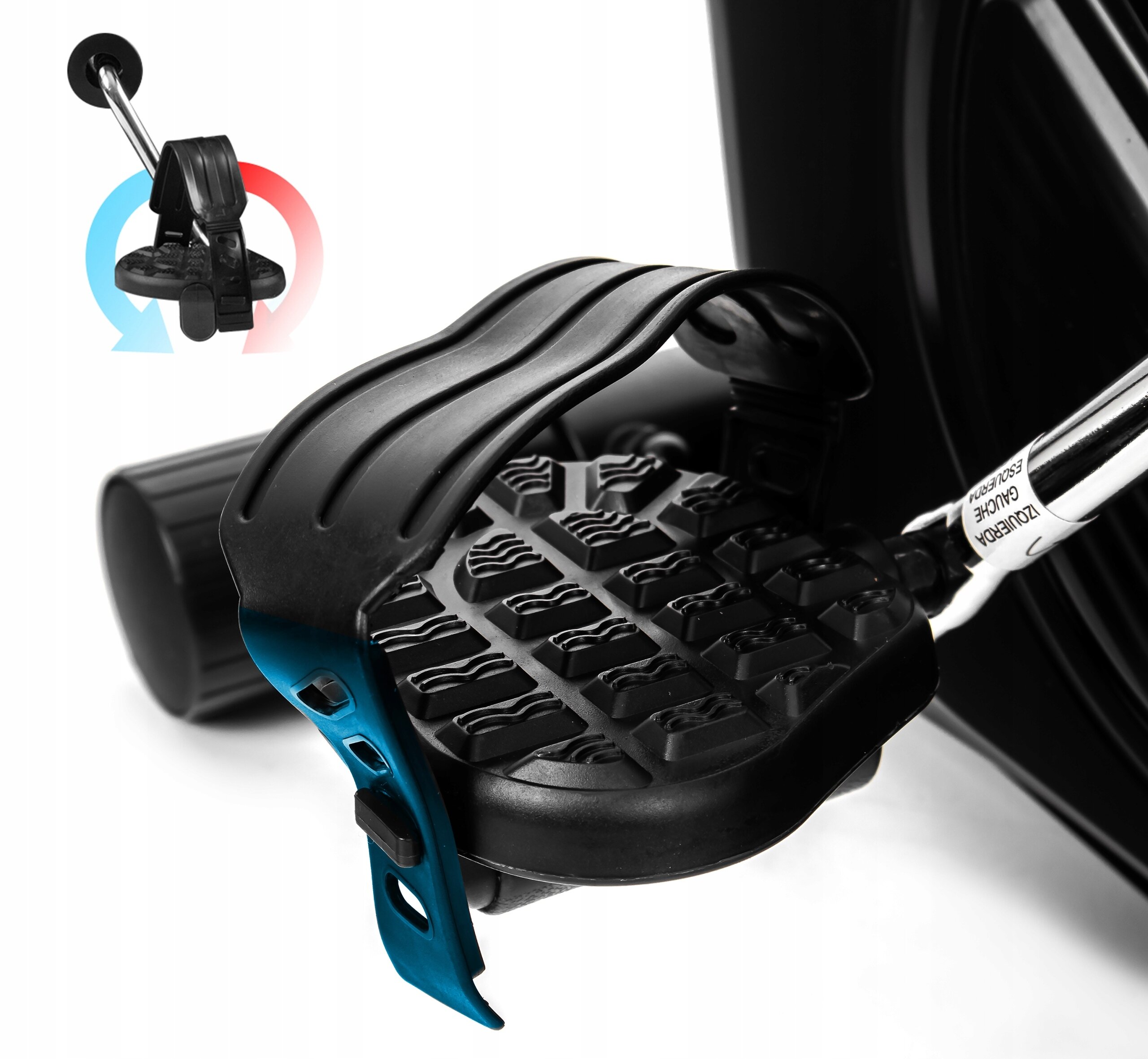 Obraz przedstawia pedał roweru treningowego z antypoślizgową powierzchnią i regulowanym paskiem. W tle widoczny jest fragment mechanizmu roweru oraz symbol w kształcie strzałki z kolorami niebieskim i czerwonym.