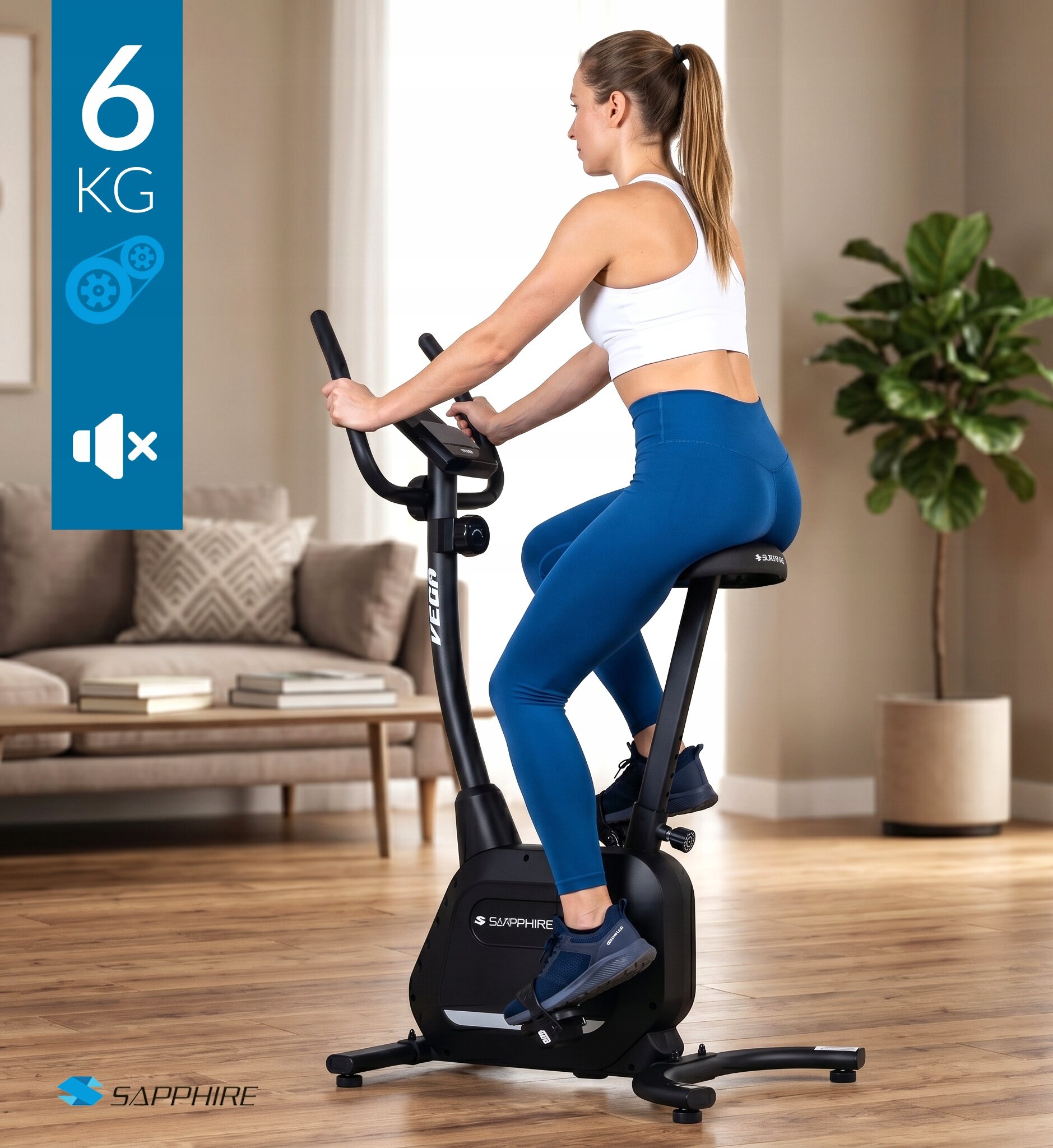 Osoba ćwiczy na czarnym rowerze treningowym magnetycznym w jasnym pomieszczeniu z rośliną i sofą w tle. Na obrazie widoczne są napisy \'6 KG\', \'SAPPHIRE\' oraz ikona głośnika z przekreśleniem.