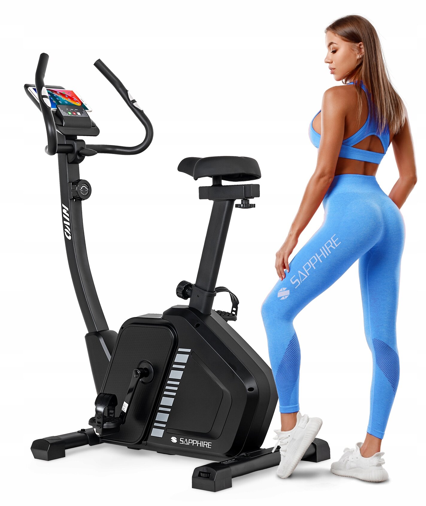 Czarny rower treningowy stacjonarny z logo \'SAPPHIRE\' na podstawie, obok stoi osoba w niebieskim stroju sportowym z napisem \'SAPPHIRE\' na nogawce.