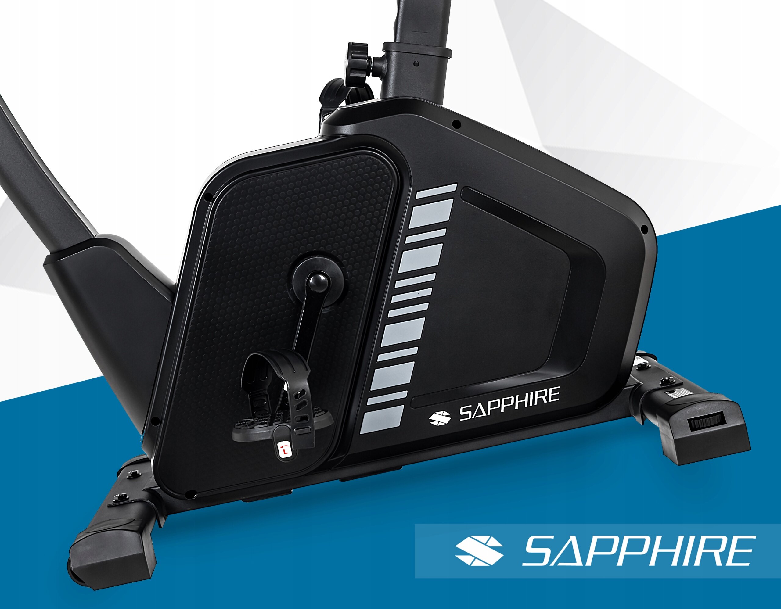 Czarny rower treningowy stacjonarny z logo \'SAPPHIRE\' na obudowie. Widoczne są pedały z paskami oraz elementy konstrukcyjne urządzenia.