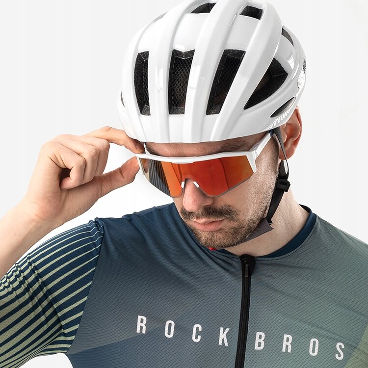 Osoba w białym kasku rowerowym nosi sportowe okulary z pomarańczowymi soczewkami. Na koszulce widoczny jest napis \'ROCKBROS\'.
