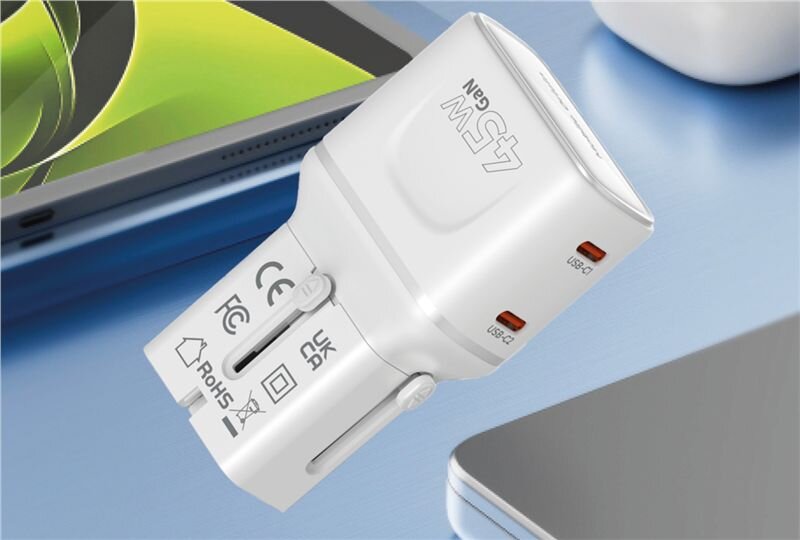 Biały adapter podróżny z oznaczeniem \'45W GaN\' oraz dwoma portami USB-C. Widoczne są symbole certyfikacji CE, FCC, UKCA i RoHS.