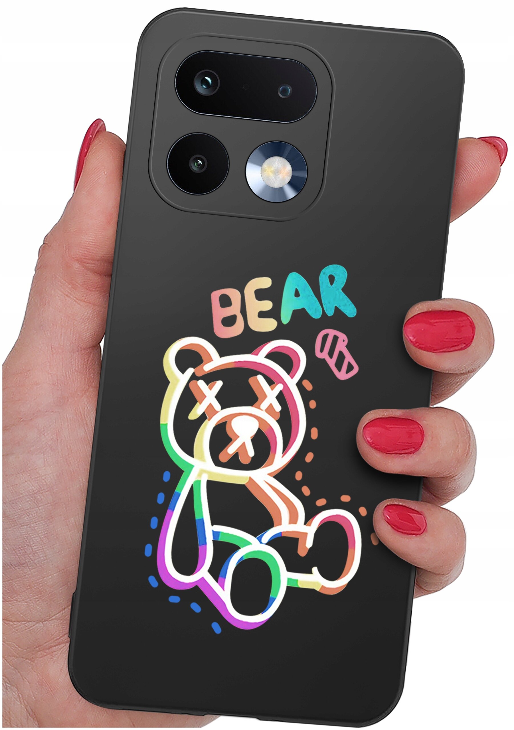 Czarna obudowa telefonu z kolorowym rysunkiem misia i napisem \'BEAR\'. Obudowa jest trzymana w dłoni z czerwonym lakierem na paznokciach.