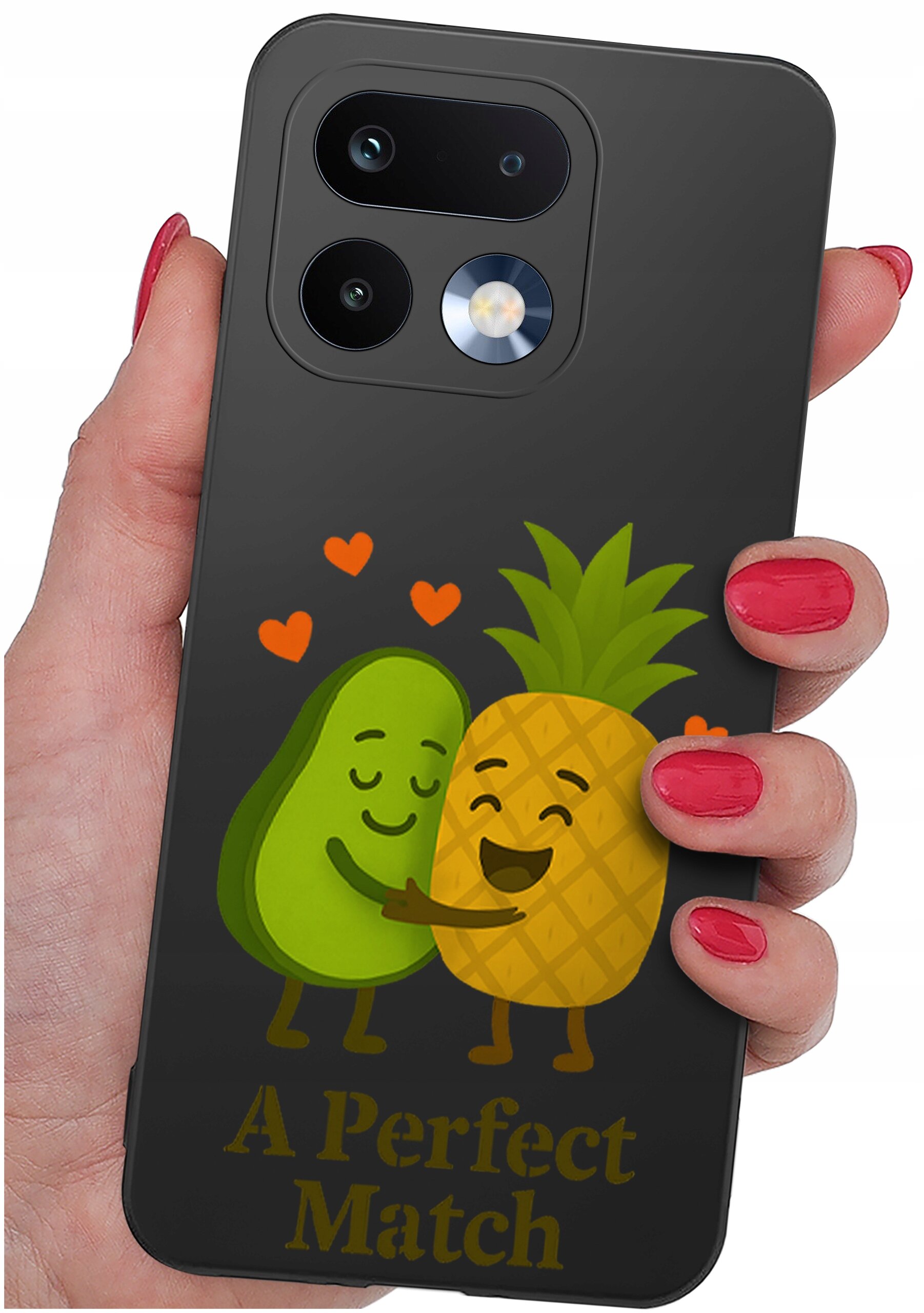 Osoba trzyma telefon w etui z grafiką przedstawiającą awokado i ananasa przytulających się, z napisem \'A Perfect Match\'.