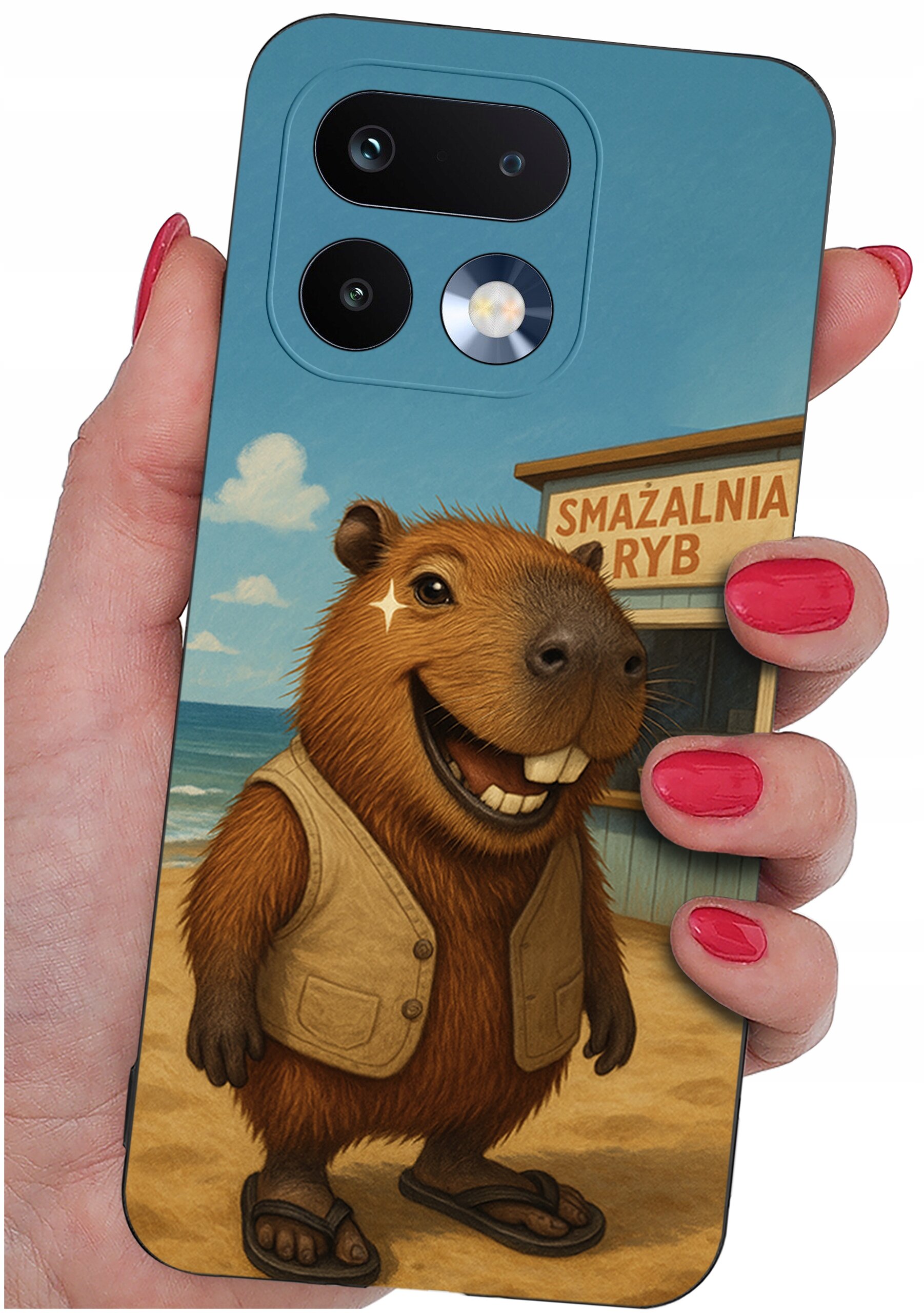 Etui na telefon z grafiką przedstawiającą uśmiechniętą kapibarę w kamizelce i sandałach, stojącą na plaży. W tle widoczny jest budynek z napisem \'SMAŻALNIA RYB\'.