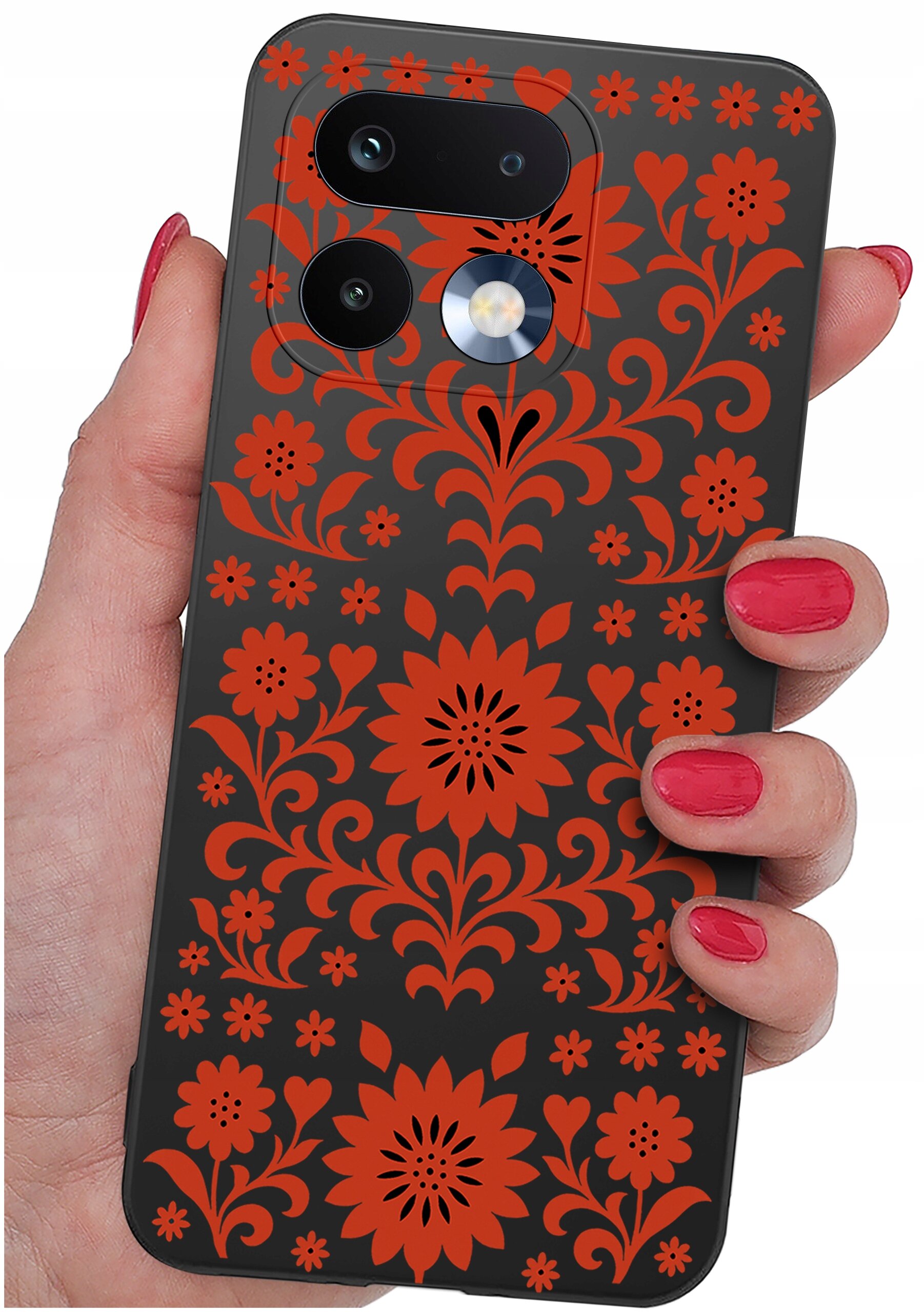 Osoba trzyma telefon w etui z czarnym tłem i czerwonym wzorem kwiatowym. Etui ma wycięcia na aparat i lampę błyskową.