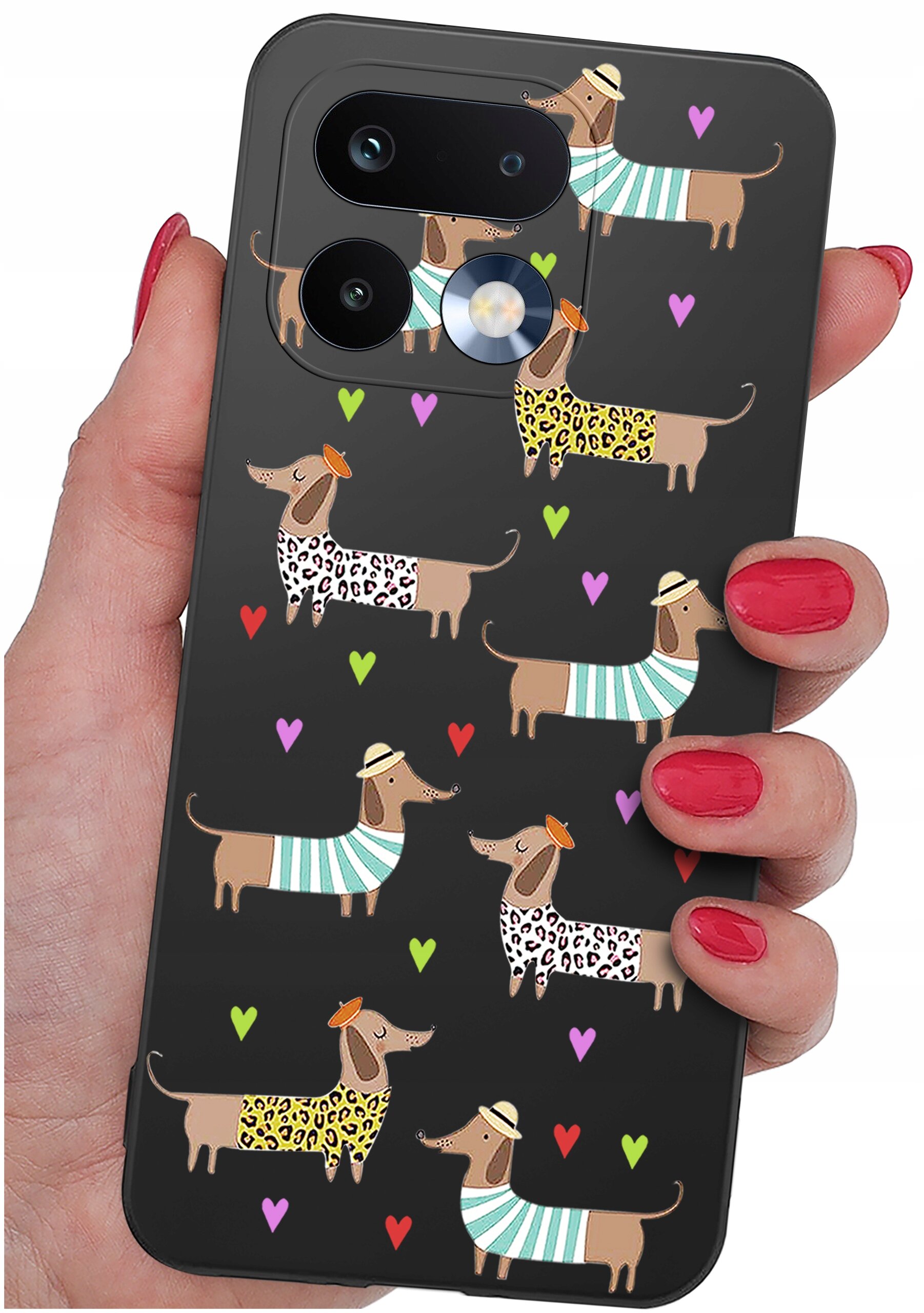 Etui na telefon z wzorem przedstawiającym psy w ubraniach w paski i cętki, otoczone kolorowymi sercami. Etui trzymane jest w dłoni z pomalowanymi na czerwono paznokciami.