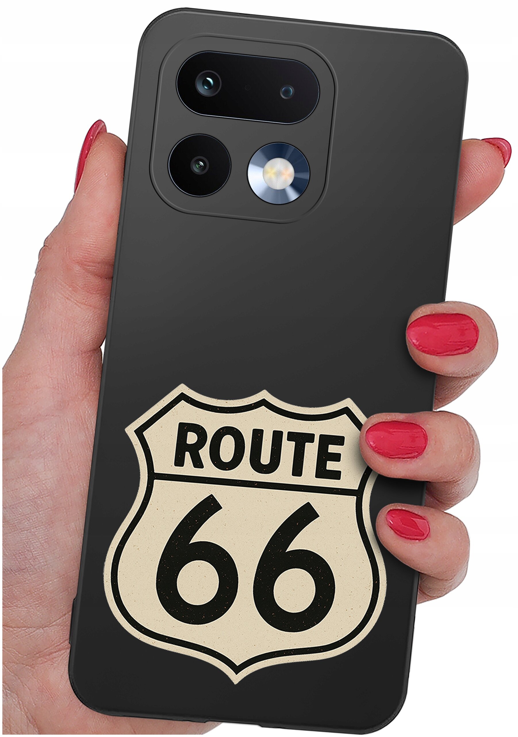 Czarna obudowa telefonu z nadrukiem znaku \'ROUTE 66\' trzymana w dłoni z pomalowanymi na czerwono paznokciami. Na obudowie widoczne są dwa obiektywy aparatu i lampa błyskowa.