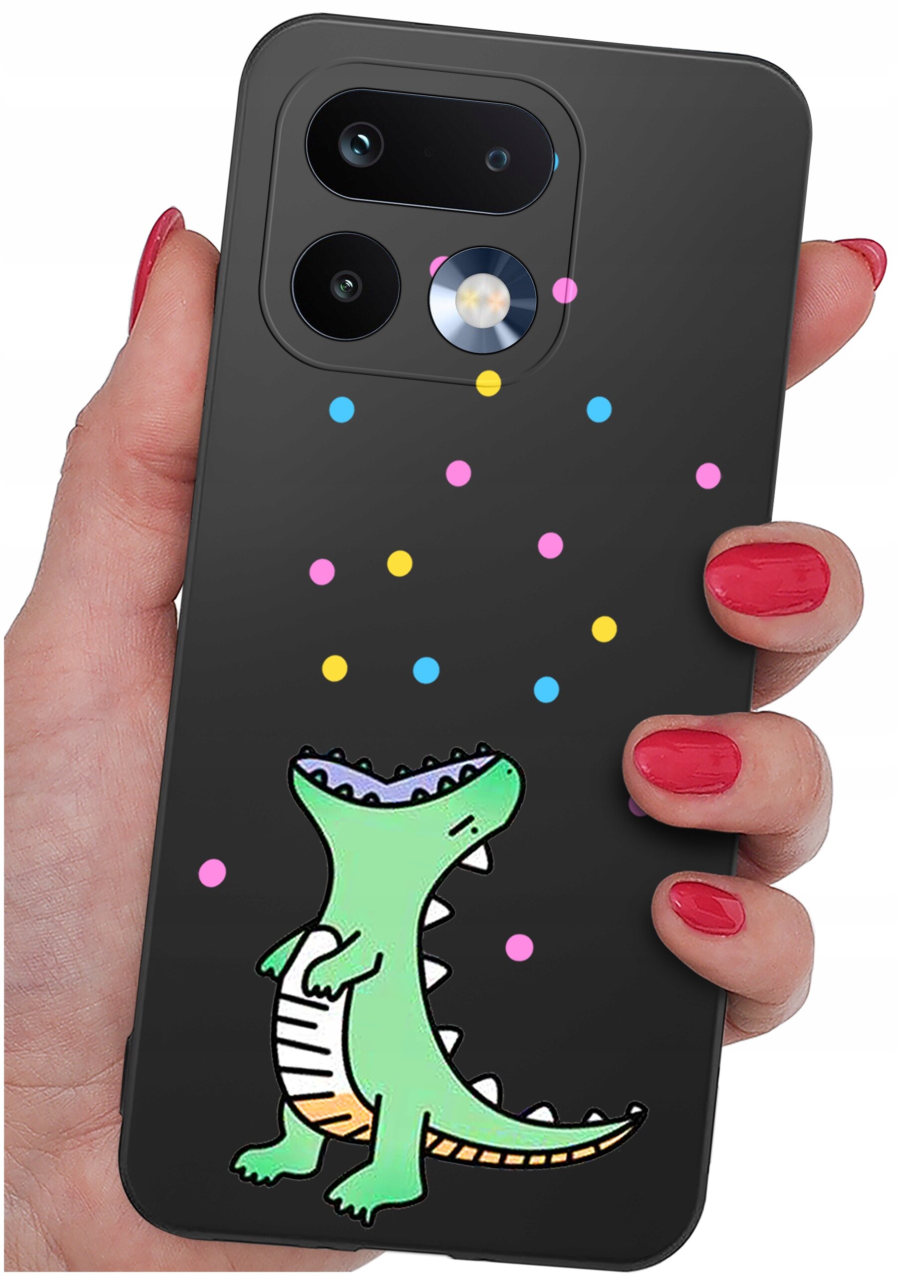 Czarne etui na telefon z kolorowym wzorem przedstawiającym zielonego dinozaura i kolorowe kropki. Etui jest trzymane w dłoni z pomalowanymi na czerwono paznokciami.