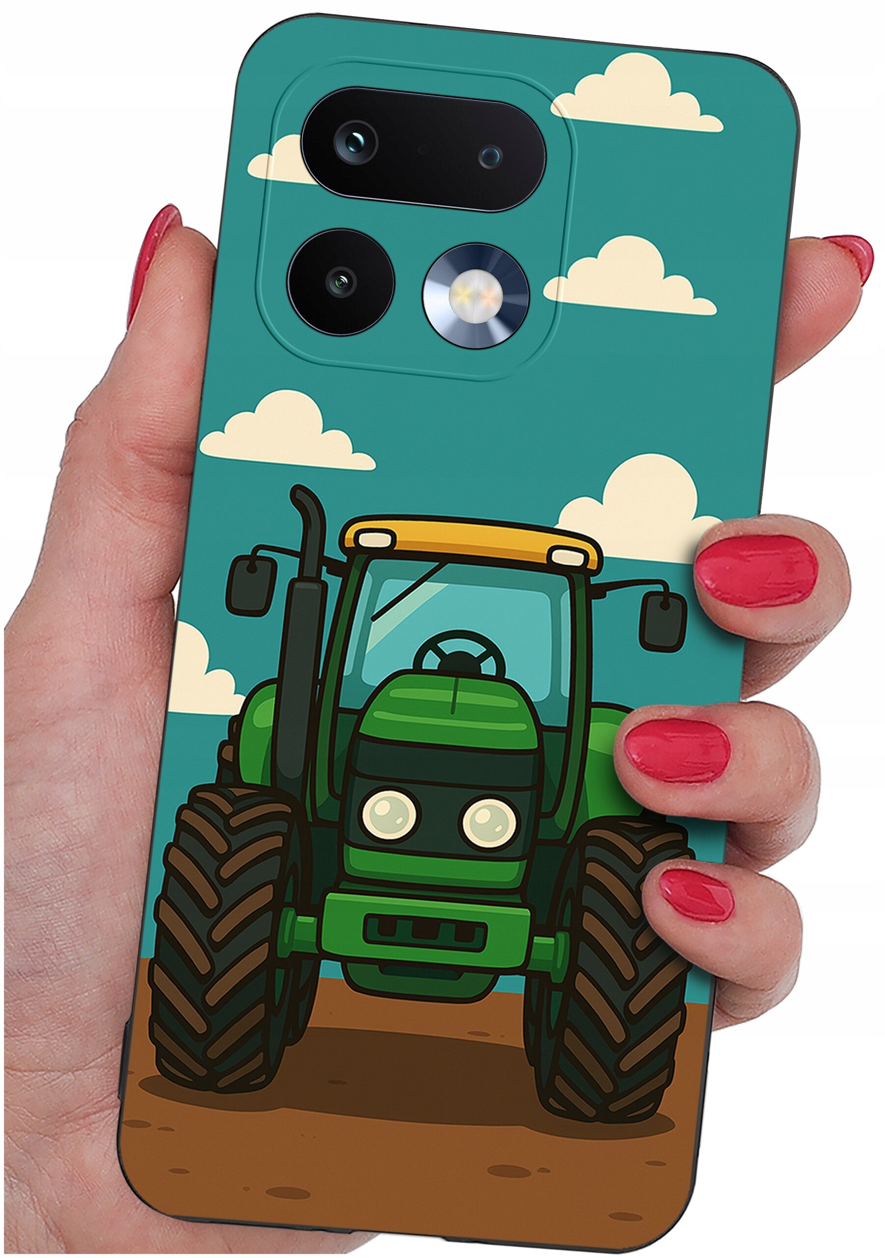 Etui na telefon z nadrukiem zielonego traktora na tle nieba z chmurami, trzymane w dłoni z pomalowanymi na czerwono paznokciami.