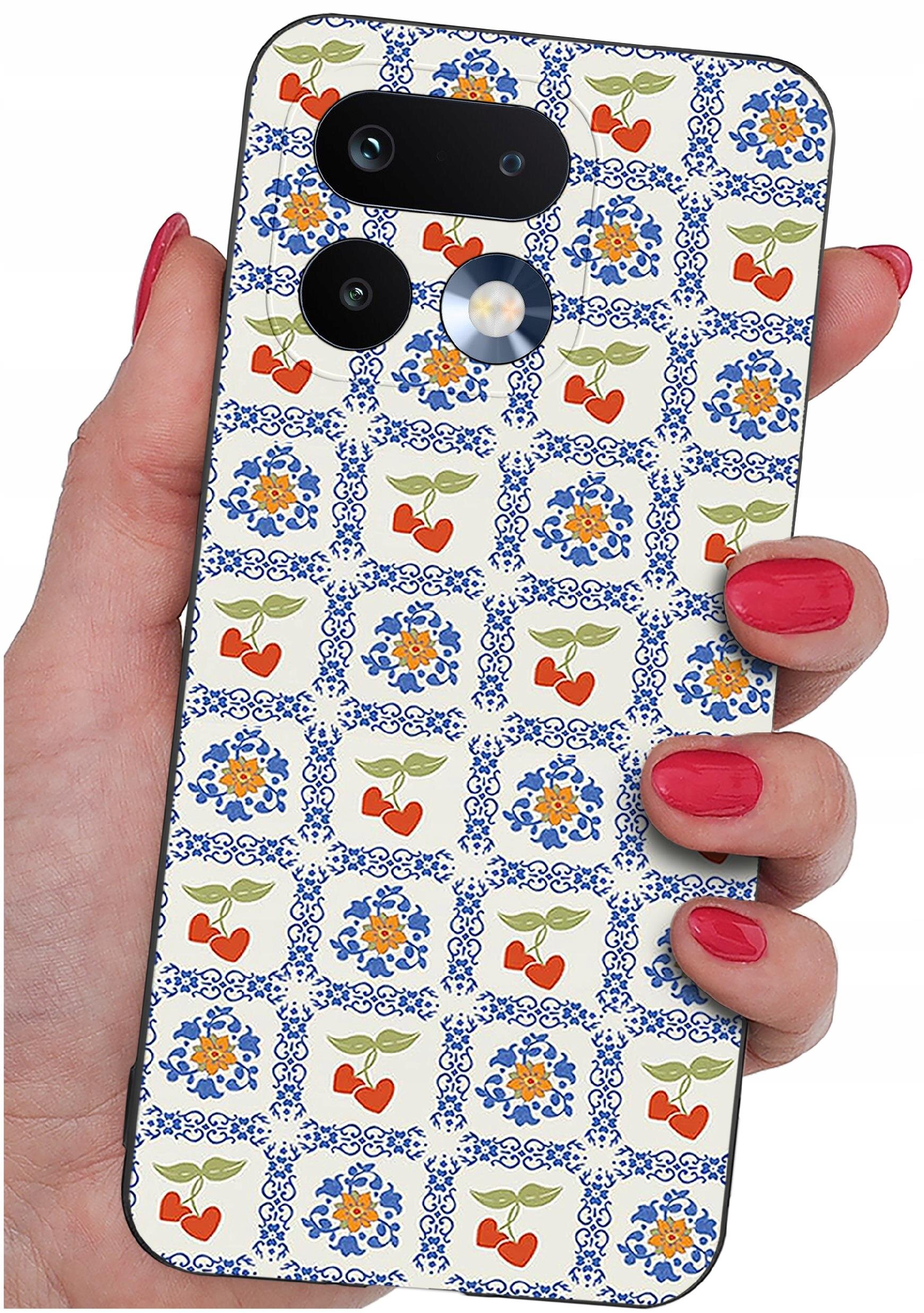 Etui na telefon z wzorem w kwiaty i serca, trzymane w dłoni z pomalowanymi na czerwono paznokciami. Etui ma otwory na aparat i lampę błyskową.