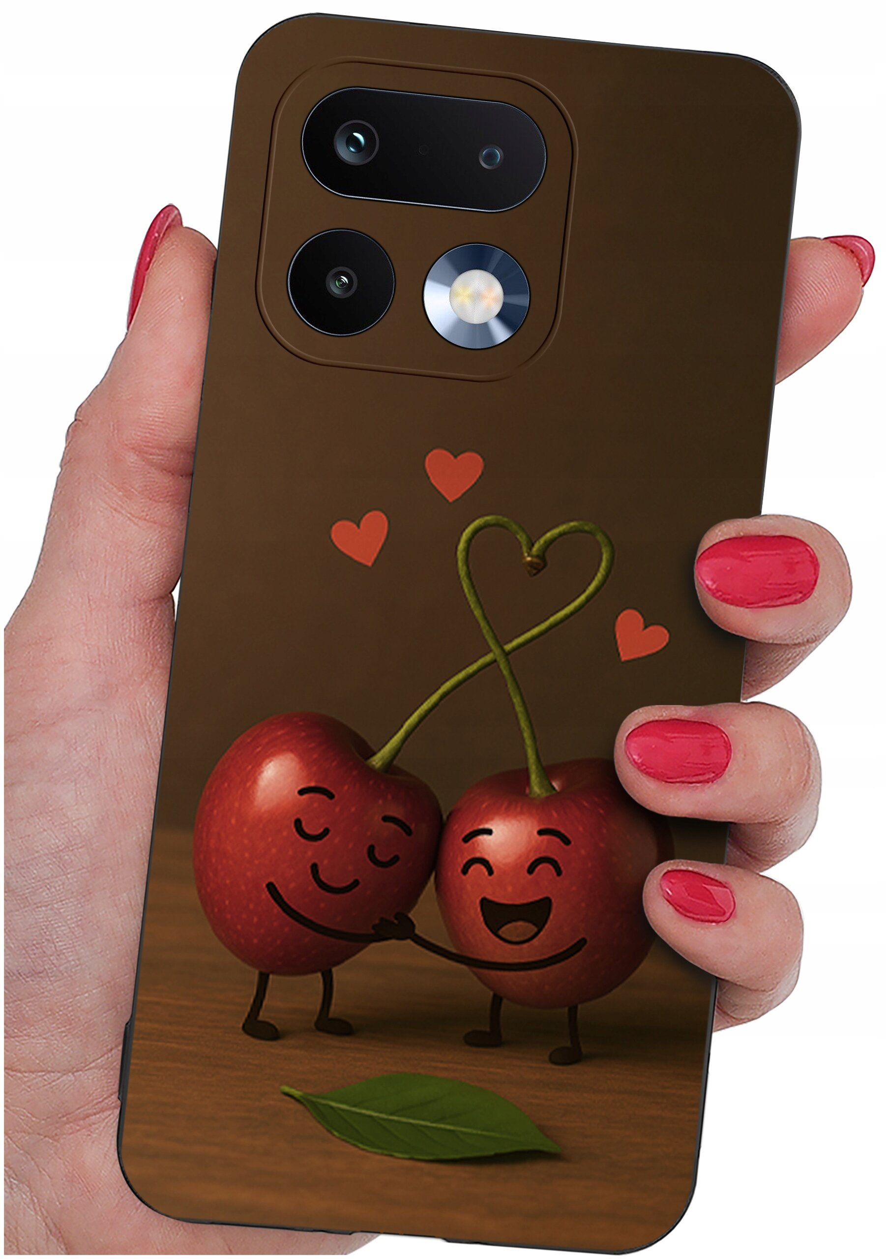 Etui na telefon z grafiką dwóch uśmiechniętych wiśni trzymających się za ręce, z serduszkami nad nimi. Etui trzymane jest w dłoni z pomalowanymi na czerwono paznokciami.