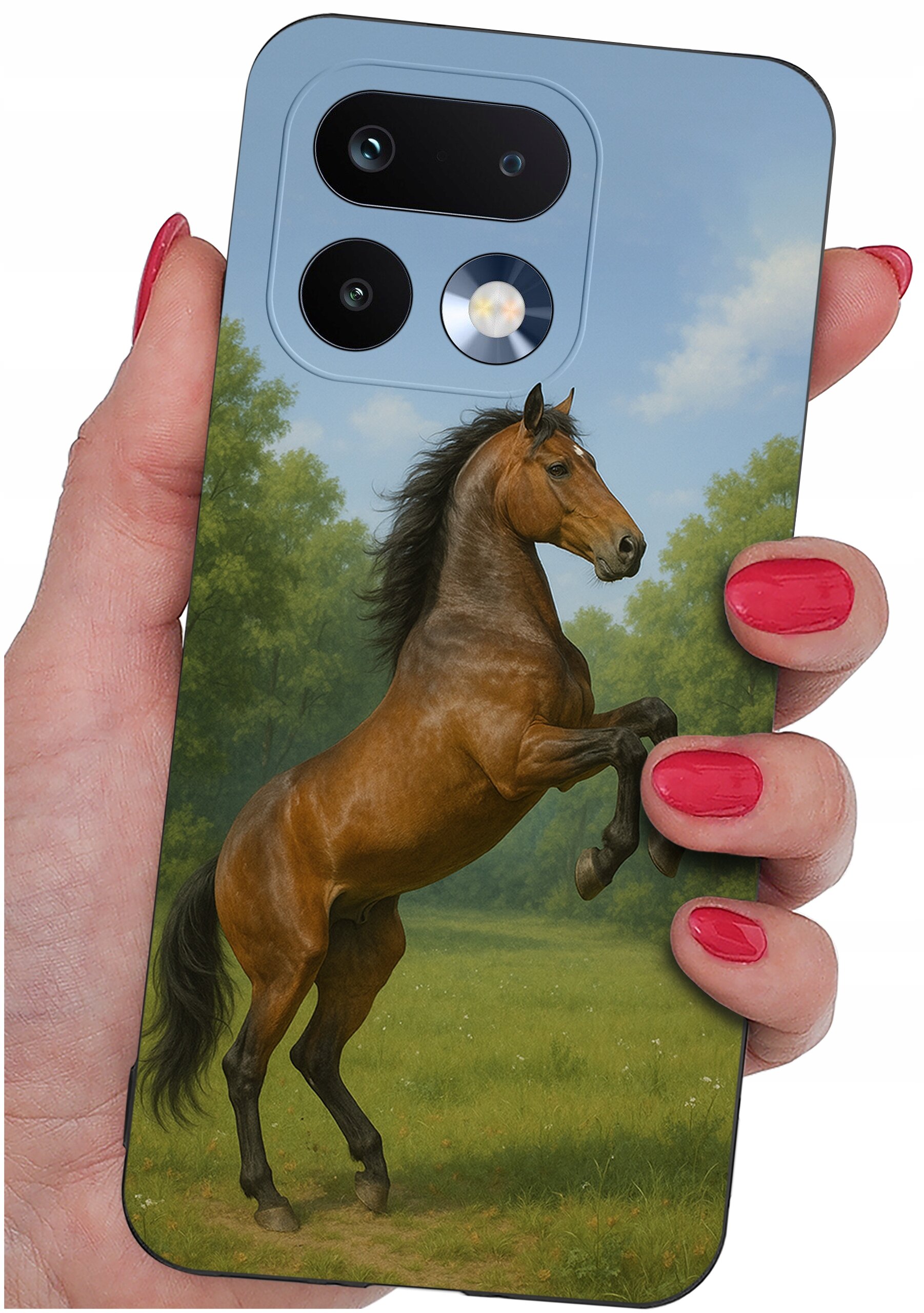Etui na telefon z nadrukiem konia na tle zielonego krajobrazu, trzymane w dłoni z pomalowanymi na czerwono paznokciami.