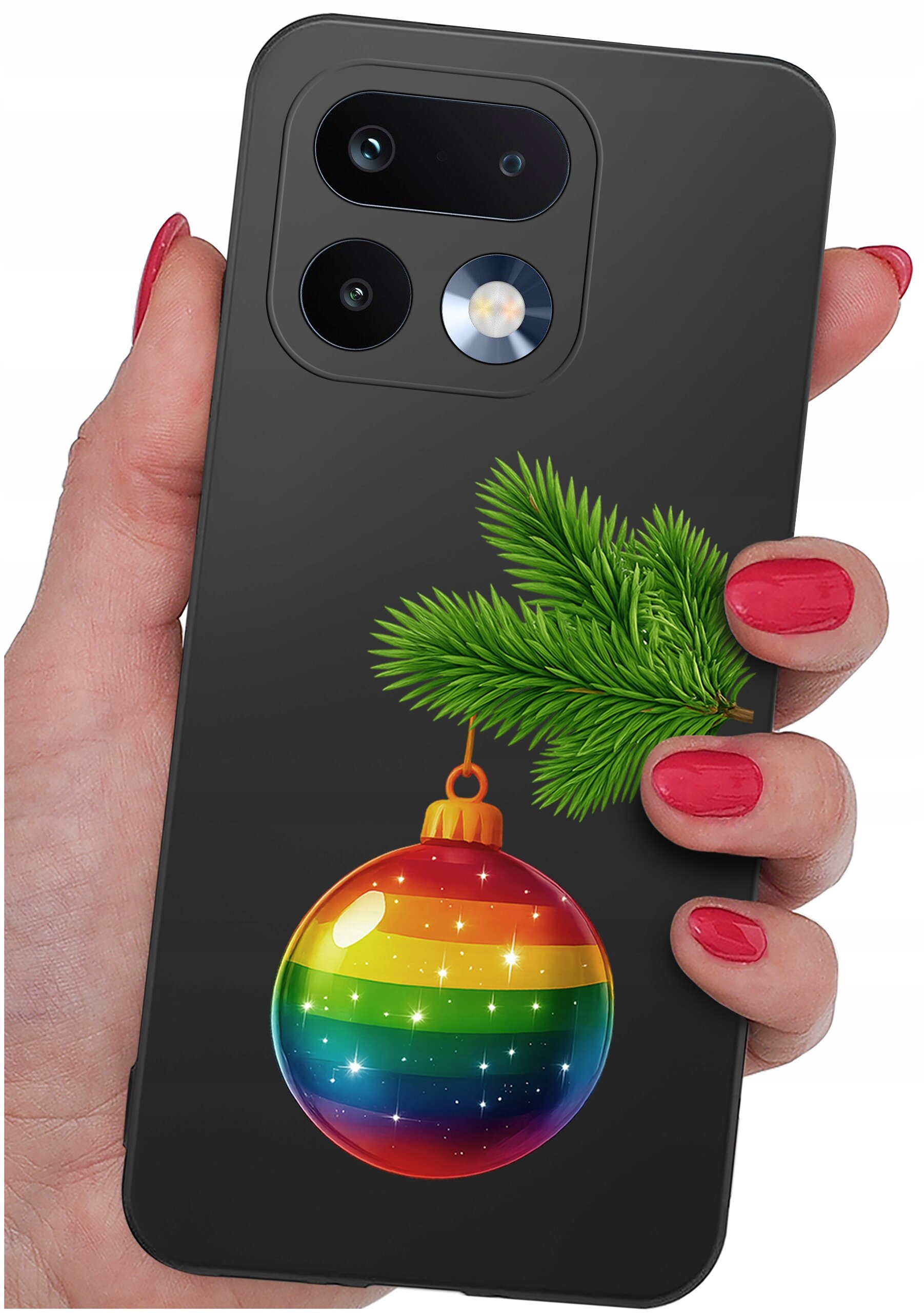 Etui na telefon z motywem świątecznym, przedstawiające gałązkę choinki i bombkę w tęczowych kolorach. Etui trzymane jest w dłoni z pomalowanymi na czerwono paznokciami.