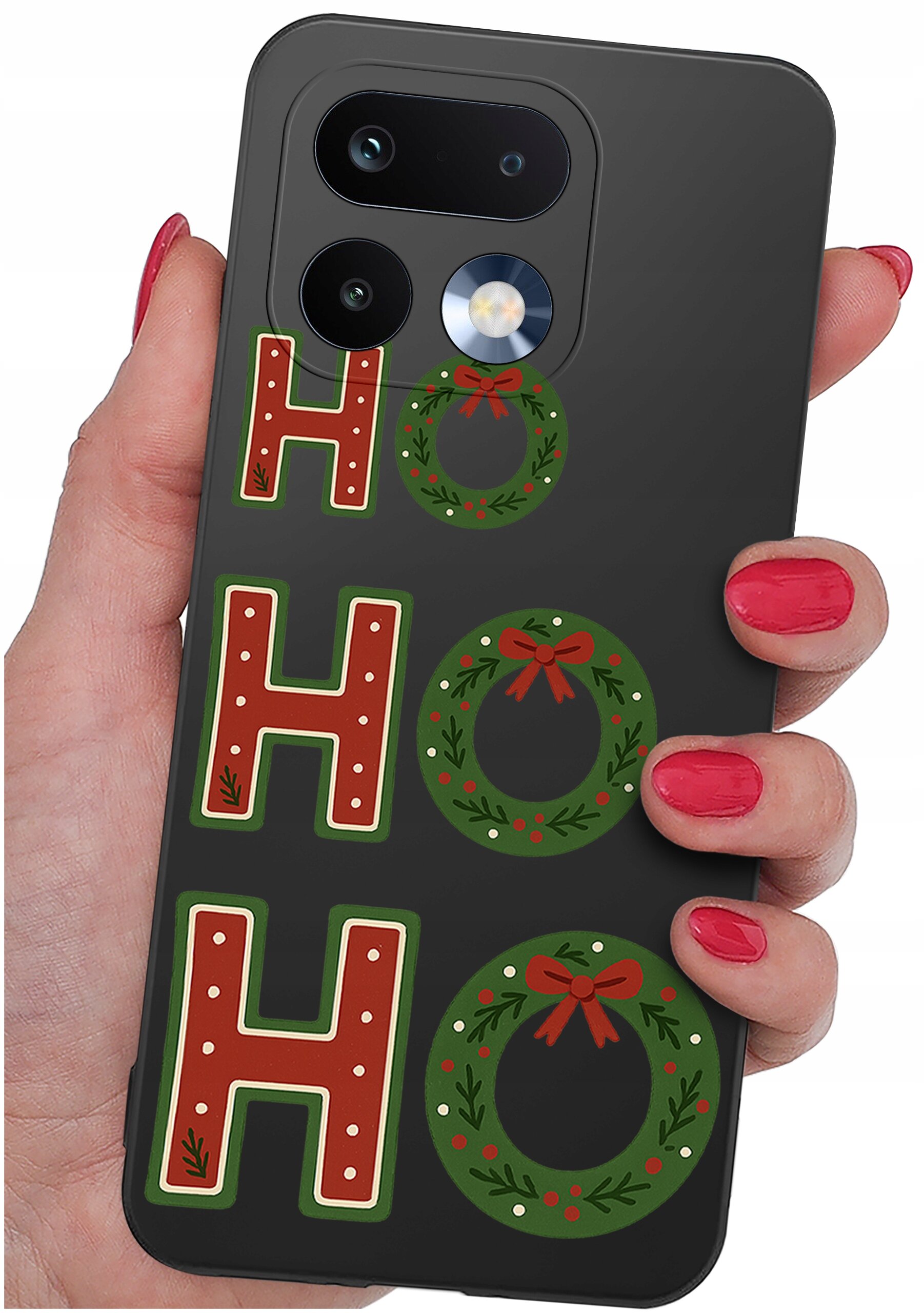 Osoba trzyma czarne etui na telefon z napisem \'HO HO HO\', gdzie litery \'O\' są zastąpione świątecznymi wieńcami. Etui ma wycięcia na aparat i lampę błyskową.