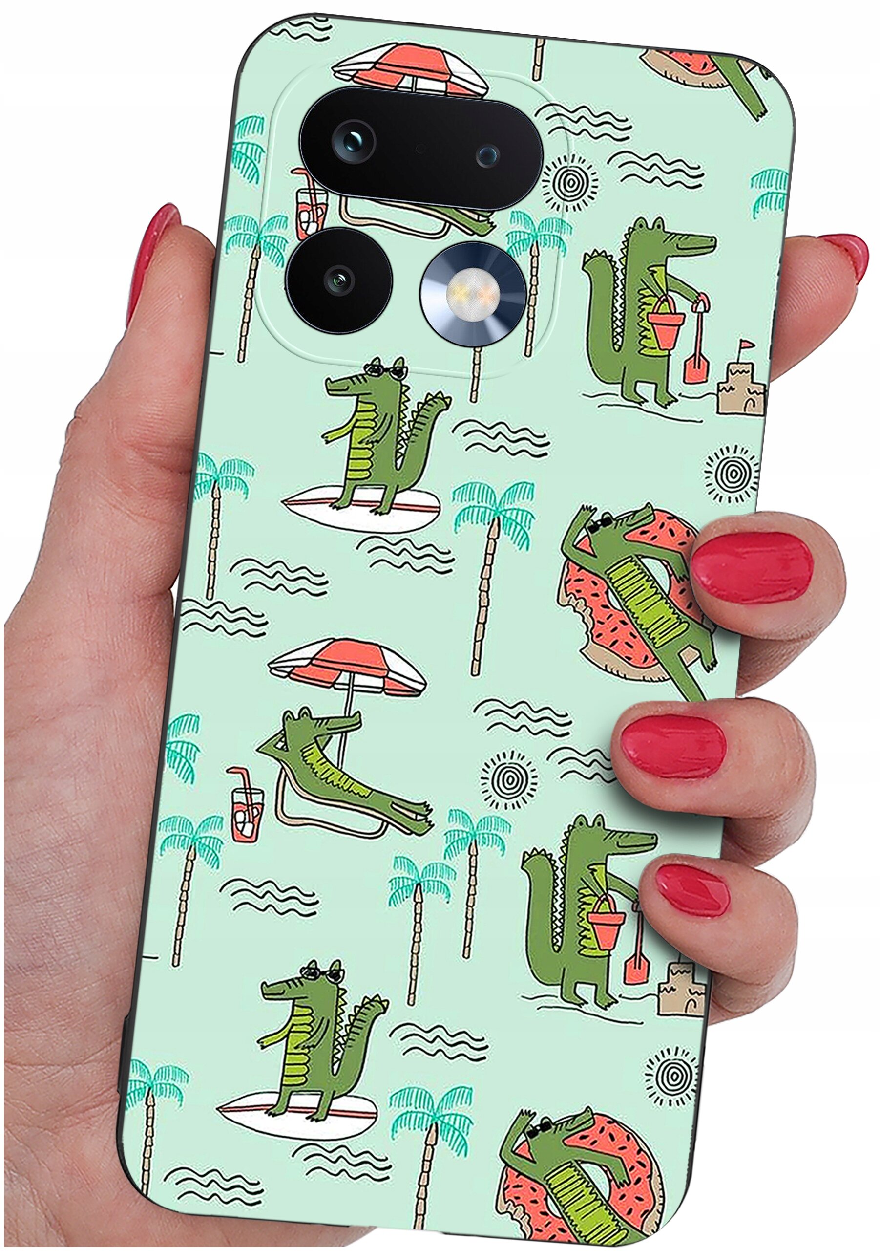 Etui na telefon z wzorem przedstawiającym zielone krokodyle w różnych pozach na tle z palmami i parasolami. Etui jest trzymane w dłoni z pomalowanymi na czerwono paznokciami.