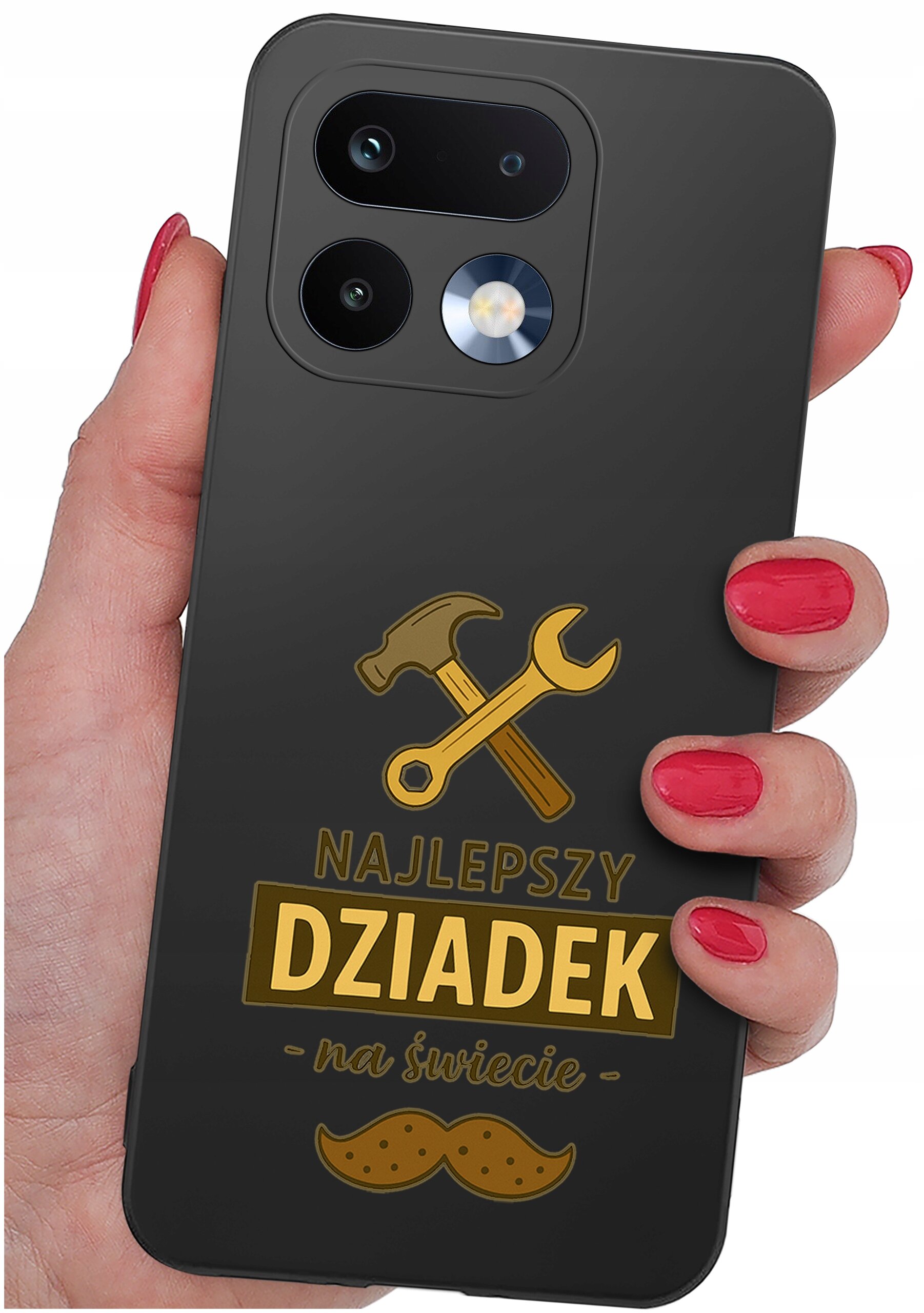 Czarna obudowa telefonu z grafiką przedstawiającą młotek i klucz oraz napisem \'NAJLEPSZY DZIADEK na świecie\'. Obudowa trzymana jest w dłoni z pomalowanymi na czerwono paznokciami.