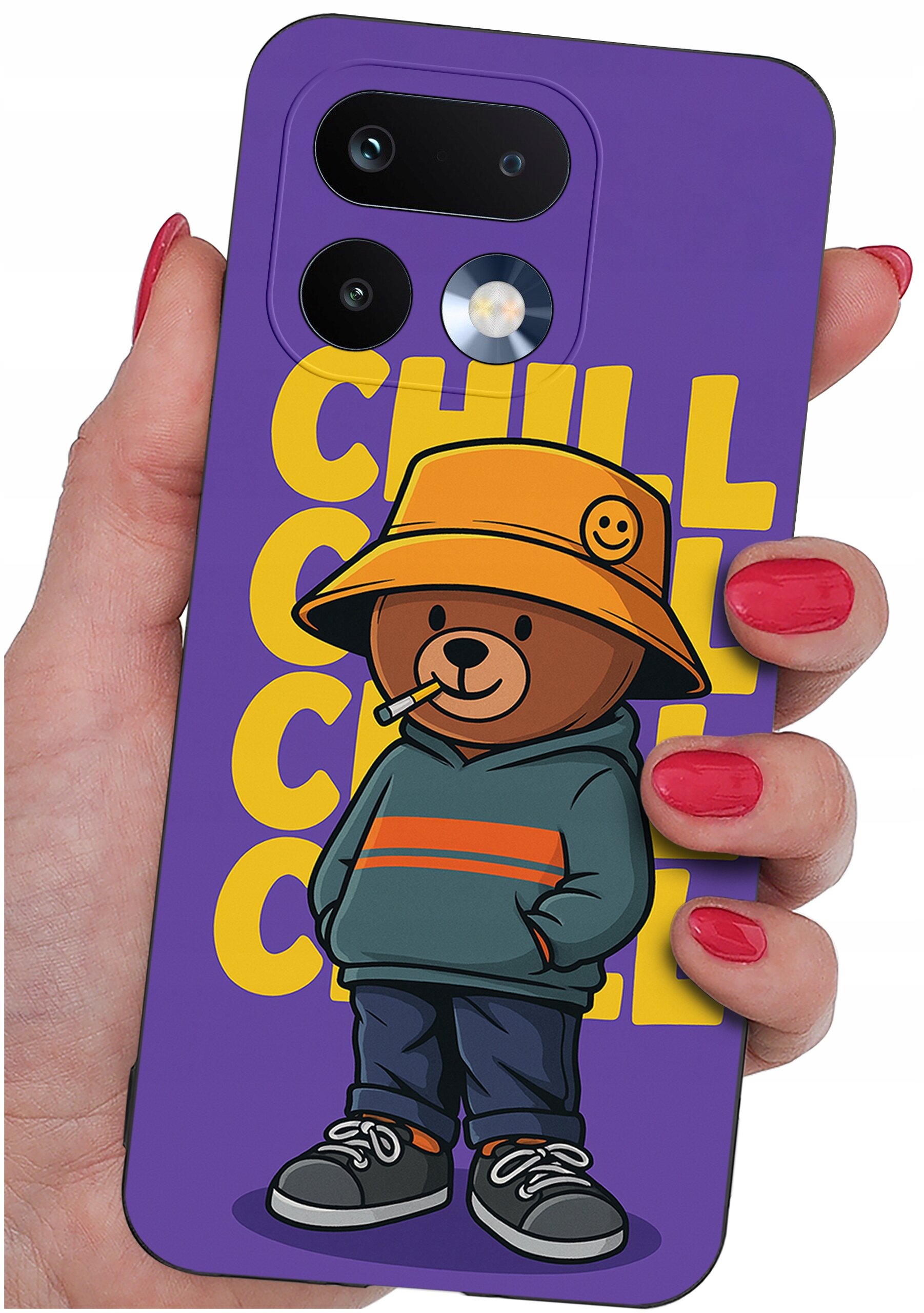 Etui na telefon w kolorze fioletowym z nadrukiem misia w pomarańczowym kapeluszu i napisem \'CHILL CHILL CHILL\'. Etui trzymane jest w dłoni z pomalowanymi na czerwono paznokciami.