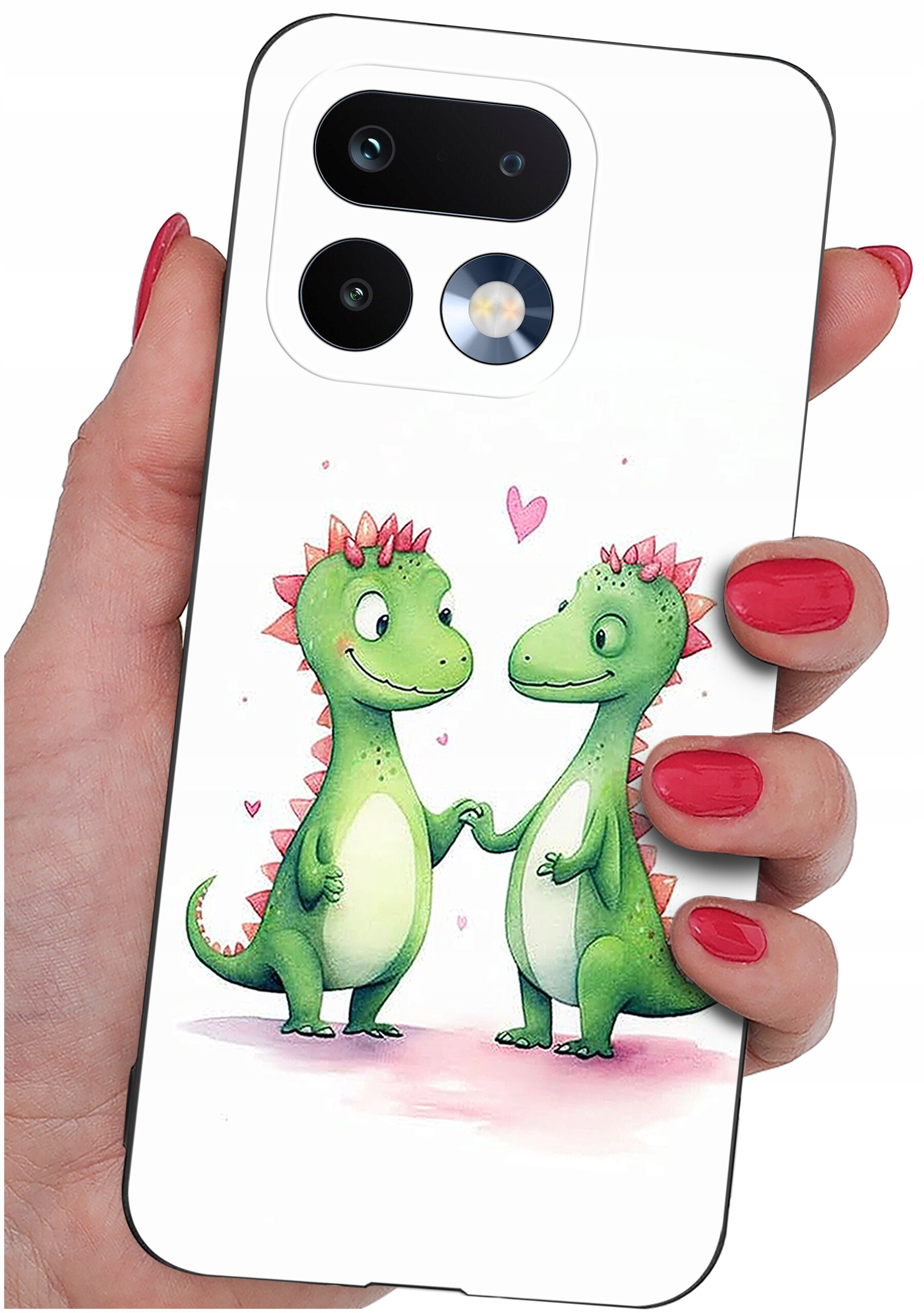 Etui na telefon z grafiką dwóch zielonych dinozaurów trzymających się za ręce, otoczonych małymi różowymi serduszkami. Etui jest trzymane w dłoni z pomalowanymi na czerwono paznokciami.