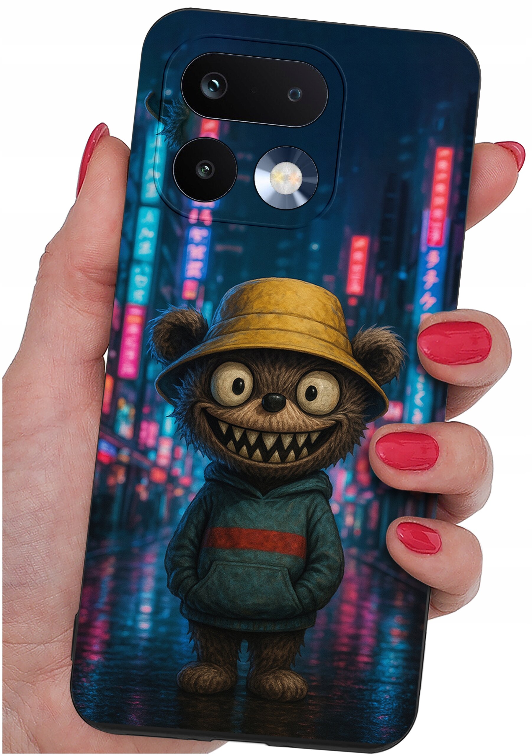 Etui na telefon z nadrukiem postaci przypominającej misia w żółtym kapeluszu i niebieskiej bluzie, trzymane w dłoni z pomalowanymi na czerwono paznokciami. W tle widoczne są rozmyte, kolorowe światła neonów.