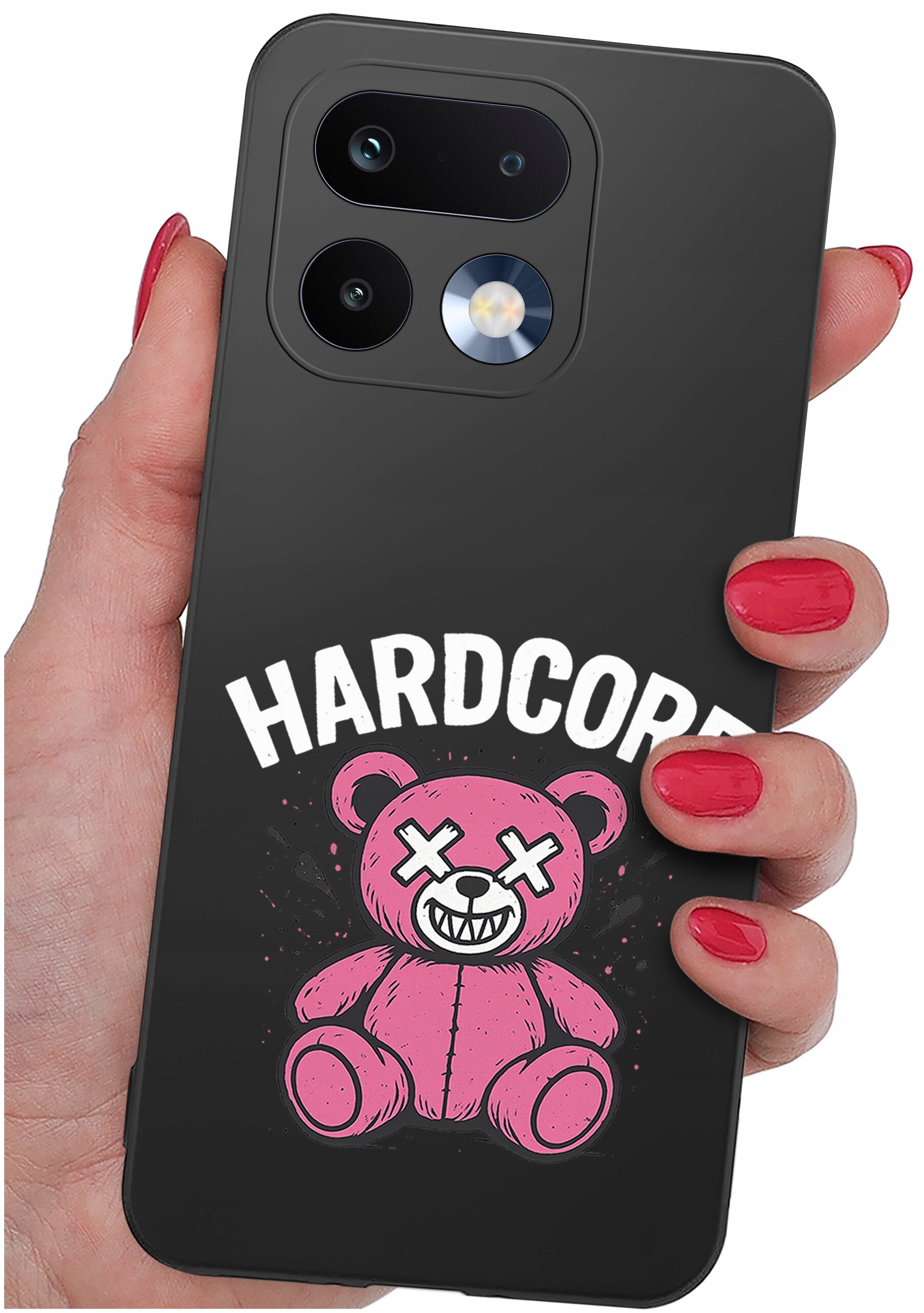 Osoba trzyma telefon z czarnym etui, na którym znajduje się różowy miś z krzyżykami zamiast oczu i napisem \'HARDCORE\'.