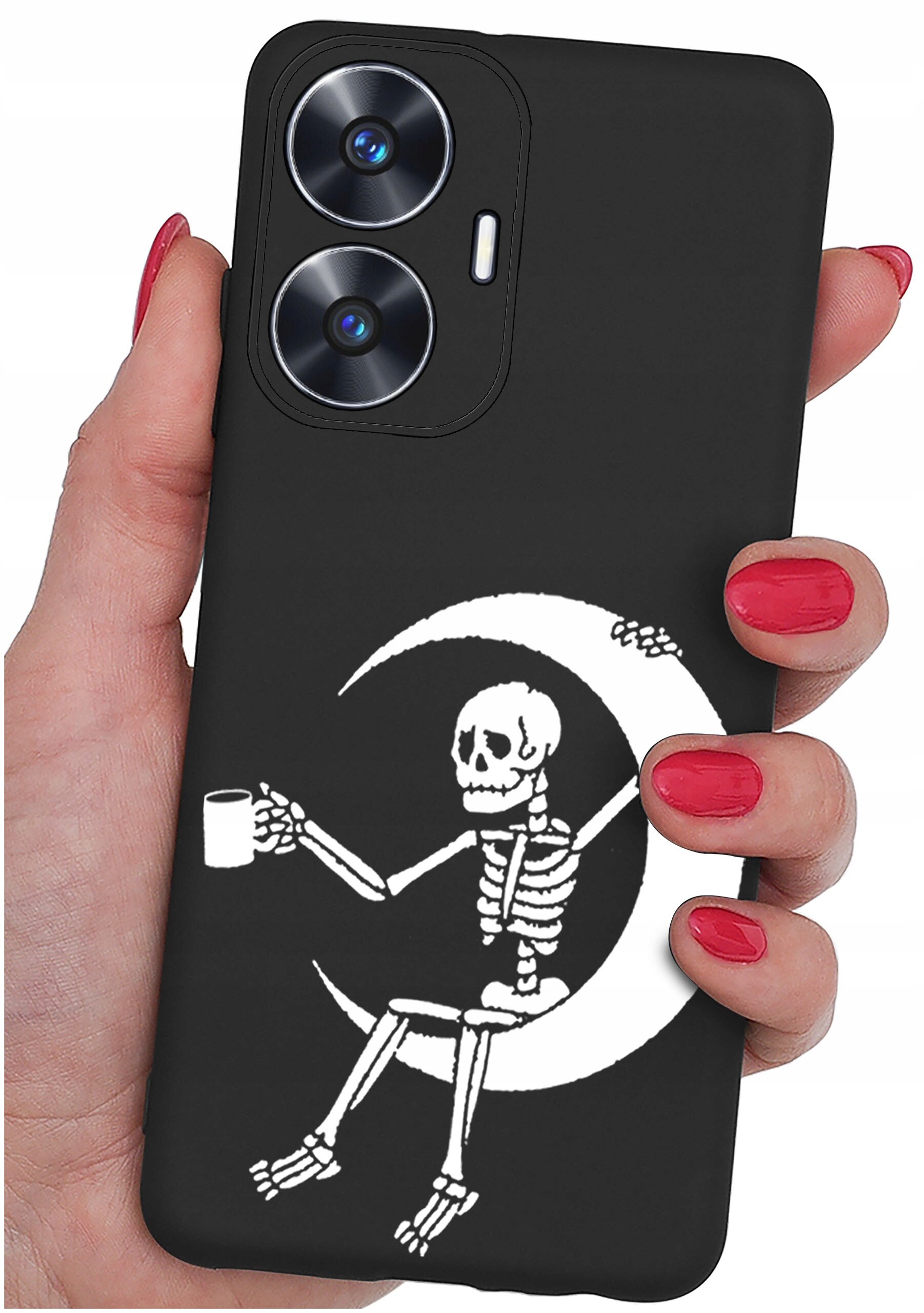 Czarne etui na telefon z nadrukiem białego szkieletu siedzącego na księżycu, trzymającego kubek. Etui jest trzymane w dłoni z pomalowanymi na czerwono paznokciami.