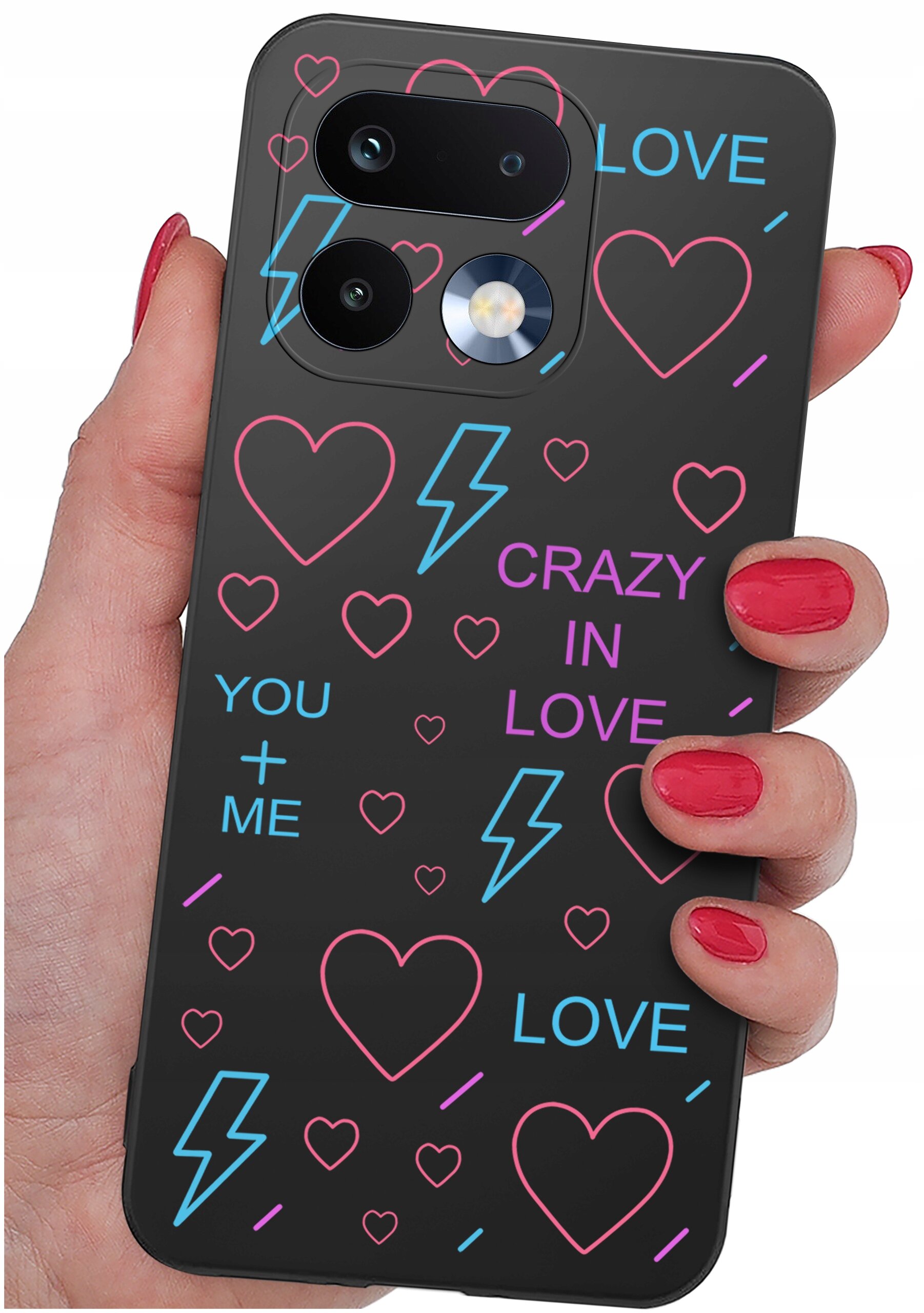 Czarne etui na telefon z kolorowymi wzorami serc, błyskawic i napisami: \'LOVE\', \'CRAZY IN LOVE\', \'YOU + ME\'. Etui trzymane jest w dłoni z pomalowanymi na czerwono paznokciami.