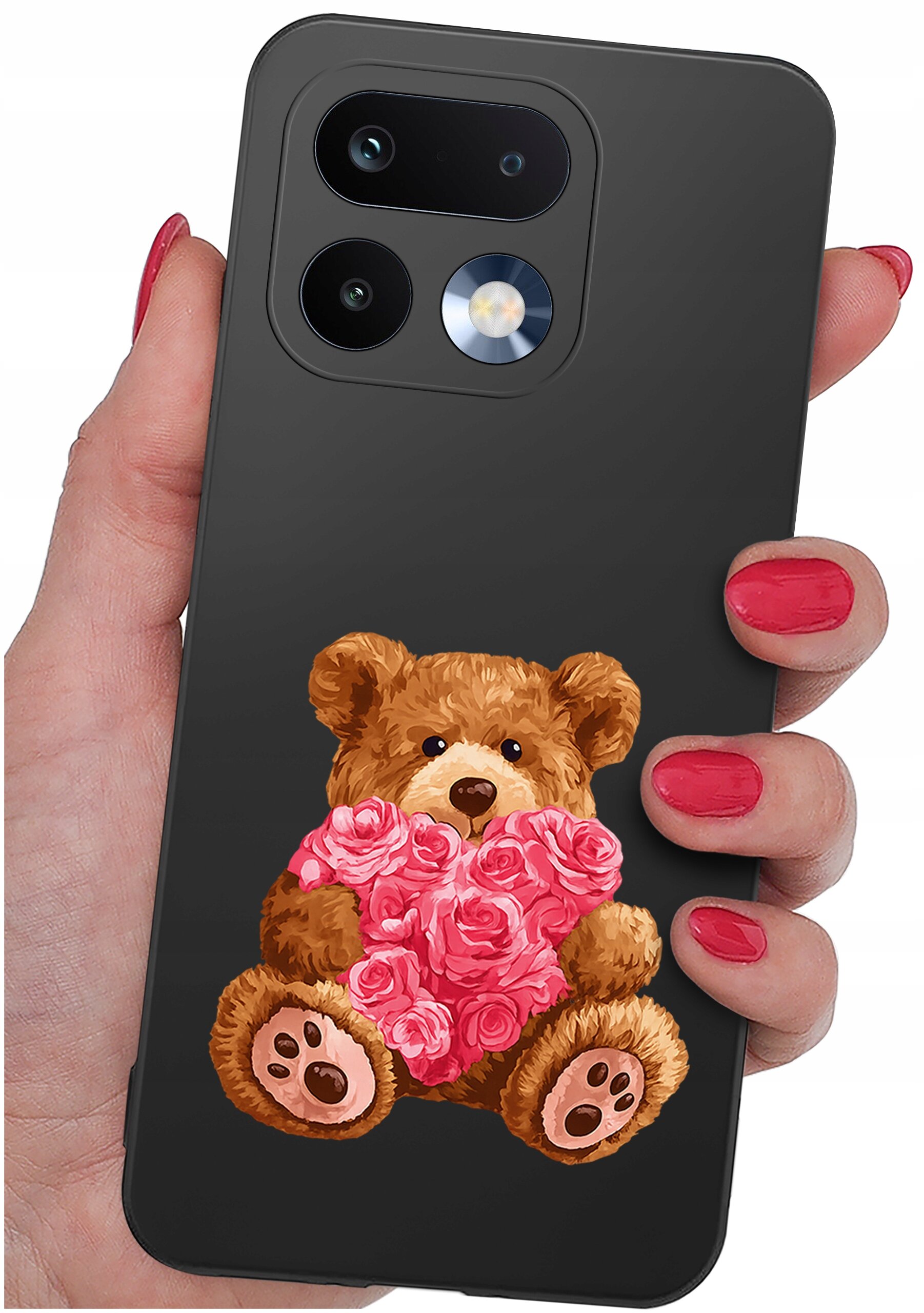Osoba trzyma telefon z czarnym etui, na którym znajduje się rysunek misia trzymającego różowe serce z kwiatów. Etui ma wycięcia na dwa obiektywy aparatu i lampę błyskową.