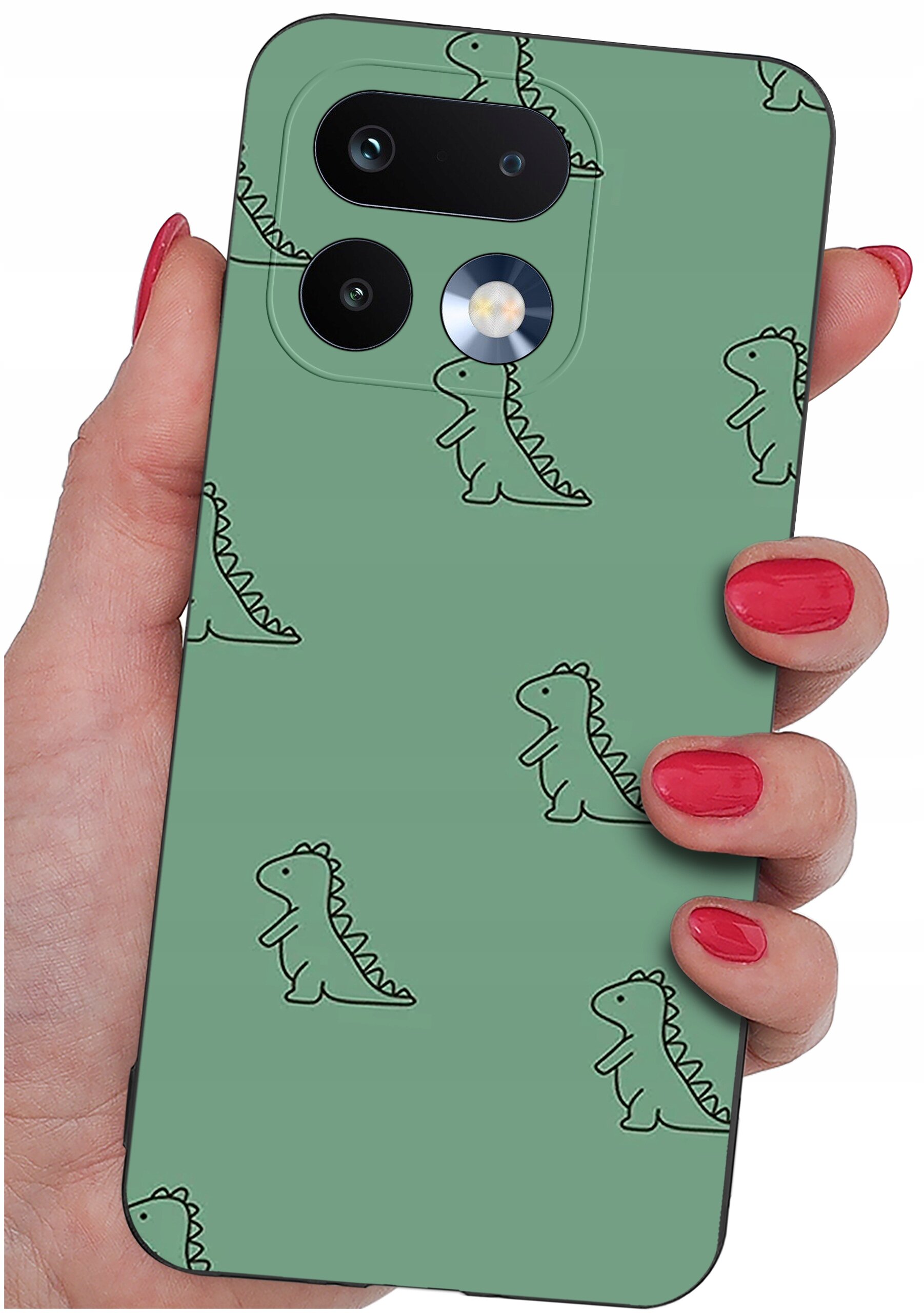 Osoba trzyma telefon z zielonym etui ozdobionym wzorem małych dinozaurów. Etui ma wycięcia na dwa obiektywy aparatu i lampę błyskową.