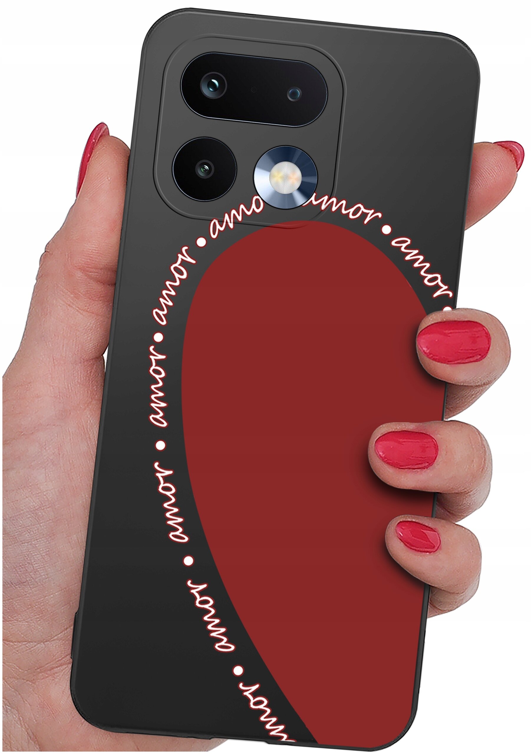 Osoba trzyma telefon z czarnym etui, na którym widoczny jest czerwony kształt serca oraz napis \'amor\' powtarzający się wokół niego. Etui ma wycięcia na dwa obiektywy aparatu i lampę błyskową.