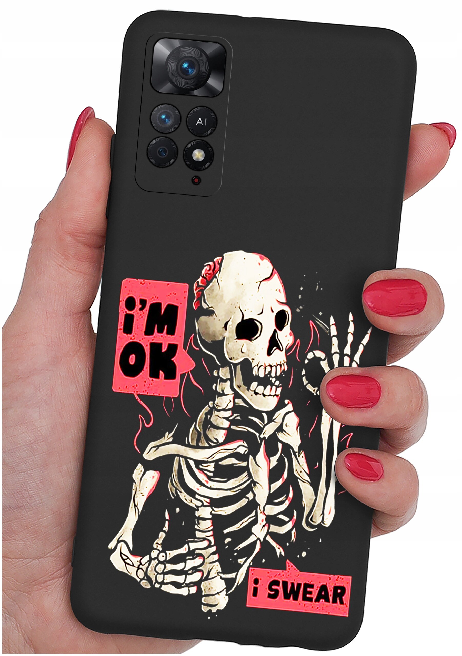 Czarna obudowa telefonu z nadrukiem szkieletu i napisami \'i\'m OK\' oraz \'i SWEAR\'. Obudowa jest trzymana w dłoni z pomalowanymi na czerwono paznokciami.