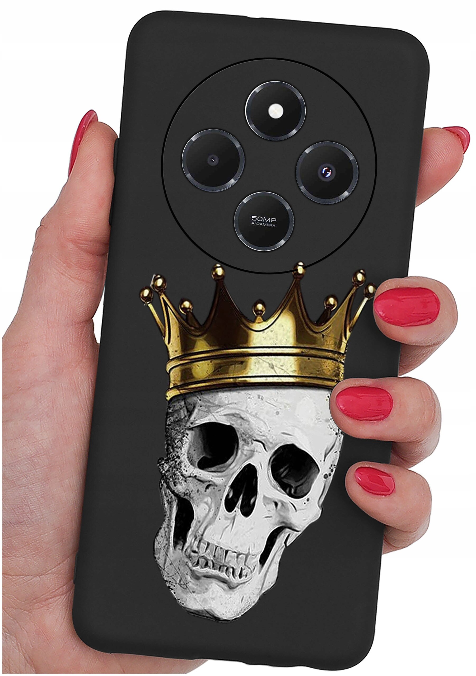 Czarna obudowa telefonu z nadrukiem czaszki w złotej koronie, trzymana w dłoni z czerwonymi paznokciami. Widoczne są trzy obiektywy aparatu i napis \'50MP\'.