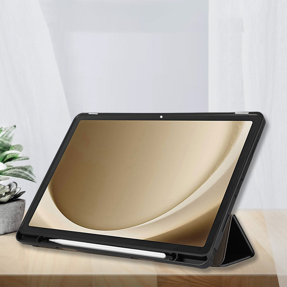 Etui na tablet ustawione w pozycji stojącej, z miejscem na rysik widocznym na dole. W tle znajduje się roślina w doniczce na drewnianym blacie.