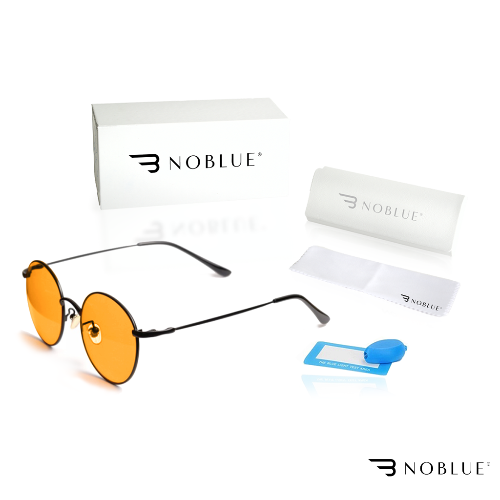 Na obrazie znajdują się okulary z pomarańczowymi soczewkami, pudełko z logo \'NOBLUE\', etui, ściereczka oraz niebieski tester światła. Logo \'NOBLUE\' widoczne jest na pudełku, etui i ściereczce.