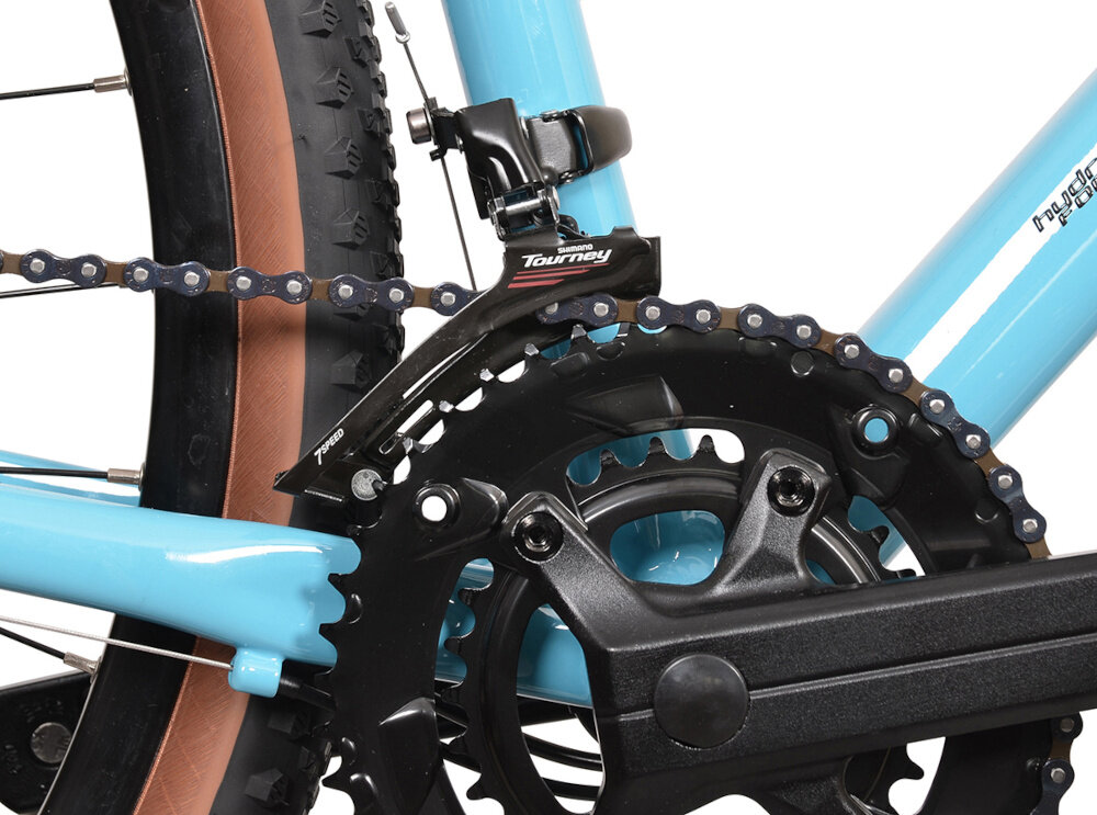 Zbliżenie na mechanizm napędowy roweru z niebieską ramą i czarnym łańcuchem. Widoczne logo \'Shimano Tourney\' na przerzutce.