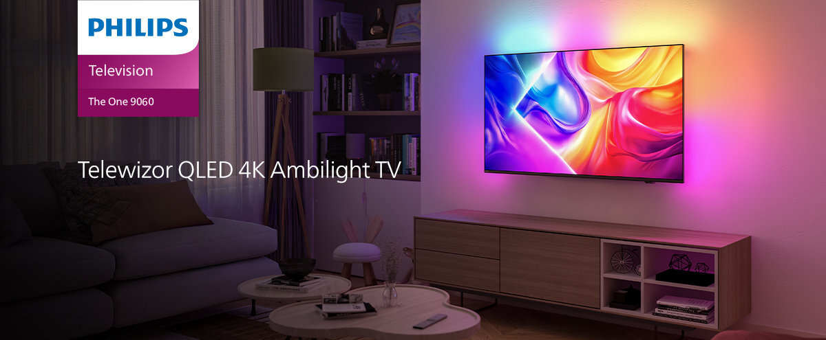 W salonie na ścianie wisi telewizor z kolorowym ekranem, emitujący światło Ambilight. Obok znajduje się tekst: \'Telewizor QLED 4K Ambilight TV\', a w lewym górnym rogu logo PHILIPS z napisem \'Television PUS9060\'.
