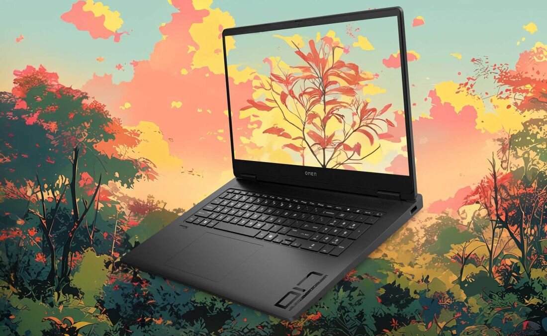Laptop z otwartym ekranem, na którym widoczny jest obraz przedstawiający kolorowe liście na tle zachodzącego słońca. Na obudowie laptopa znajduje się logo \'omen\'.