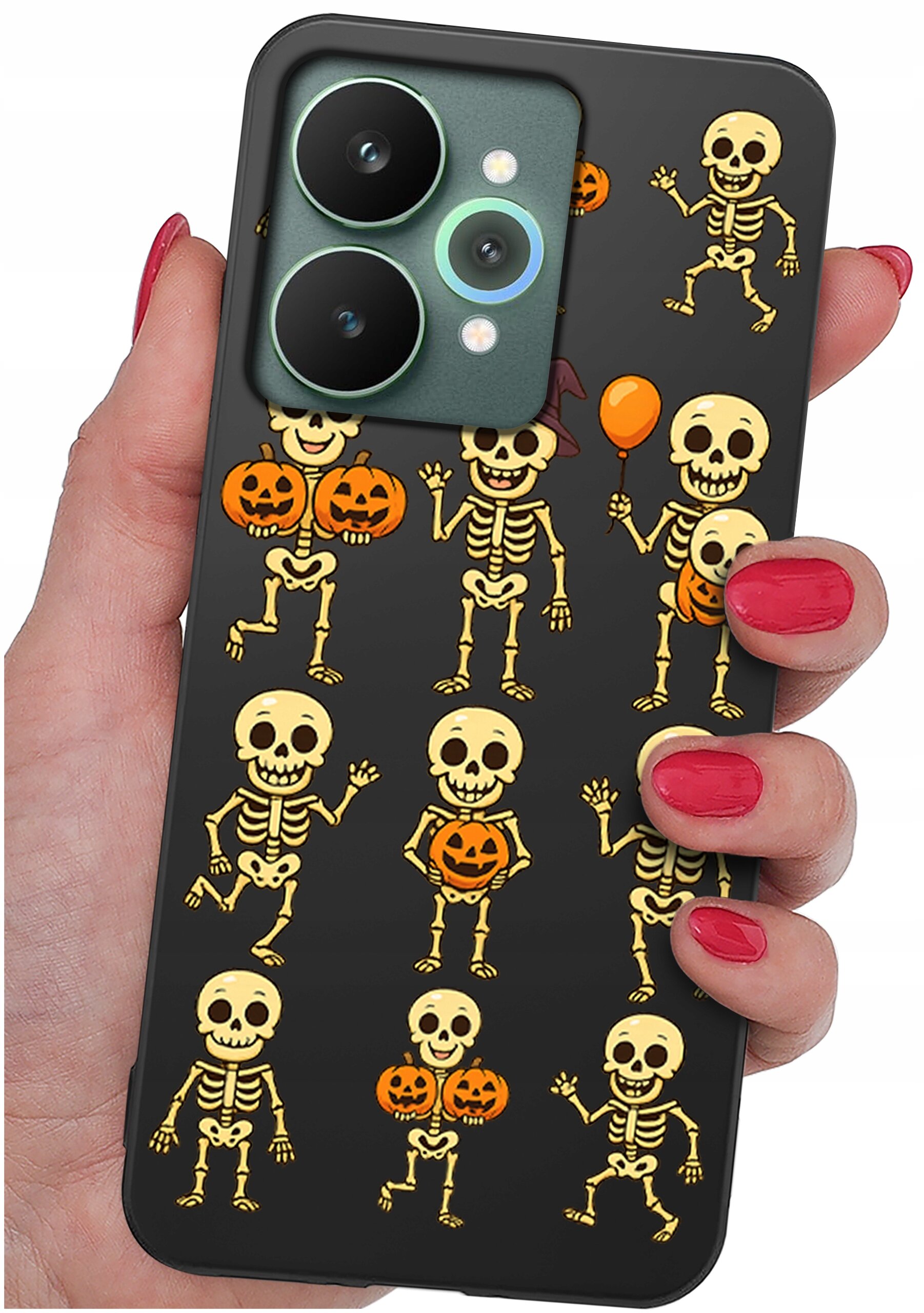 Etui na telefon z wzorem przedstawiającym szkielety i dynie na czarnym tle. Etui trzymane jest w dłoni z pomalowanymi na czerwono paznokciami.
