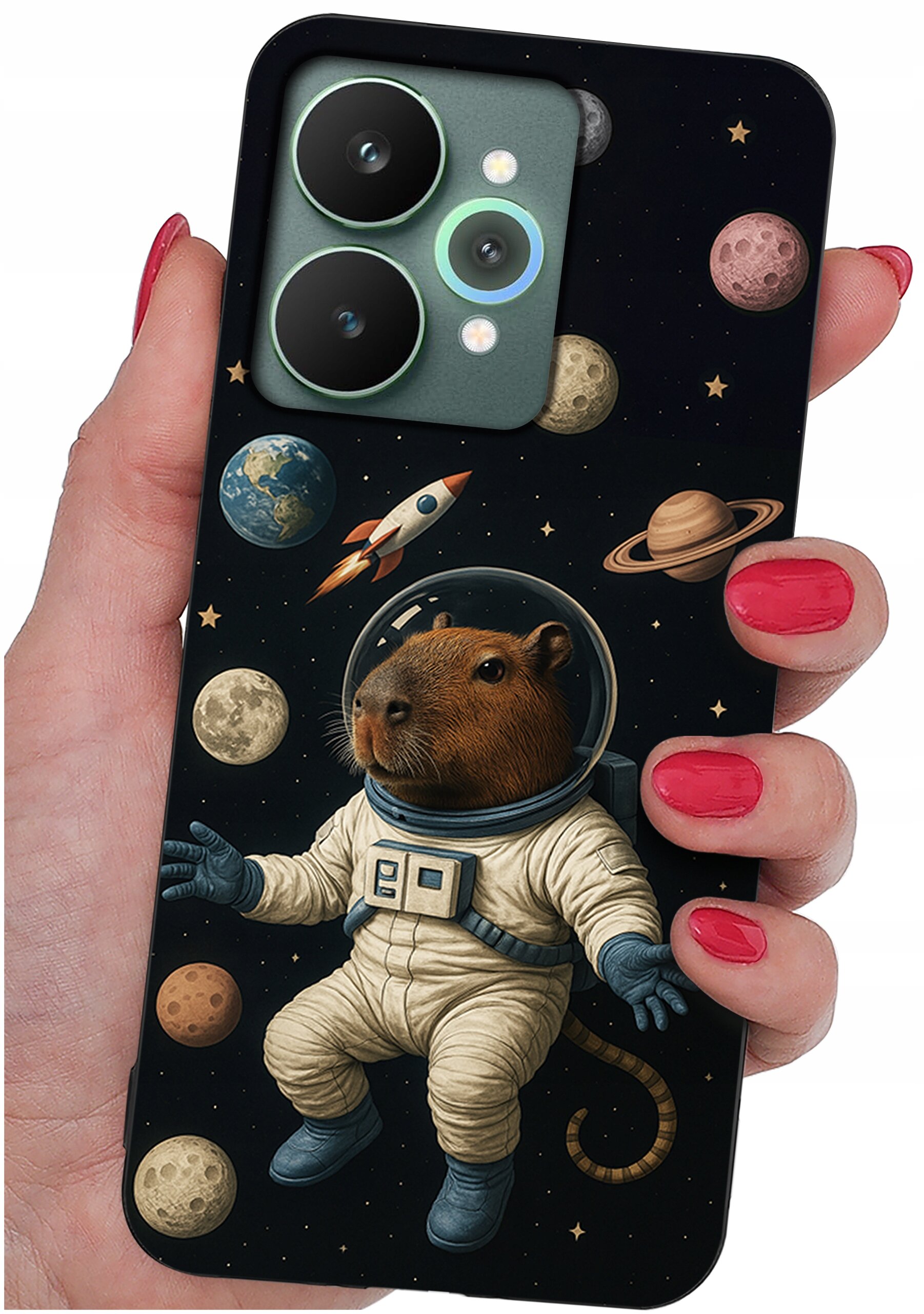 Etui na telefon z motywem kosmicznym, przedstawiające kapibarę w skafandrze astronauty otoczoną planetami i rakietą. Etui trzymane jest w dłoni z pomalowanymi na czerwono paznokciami.