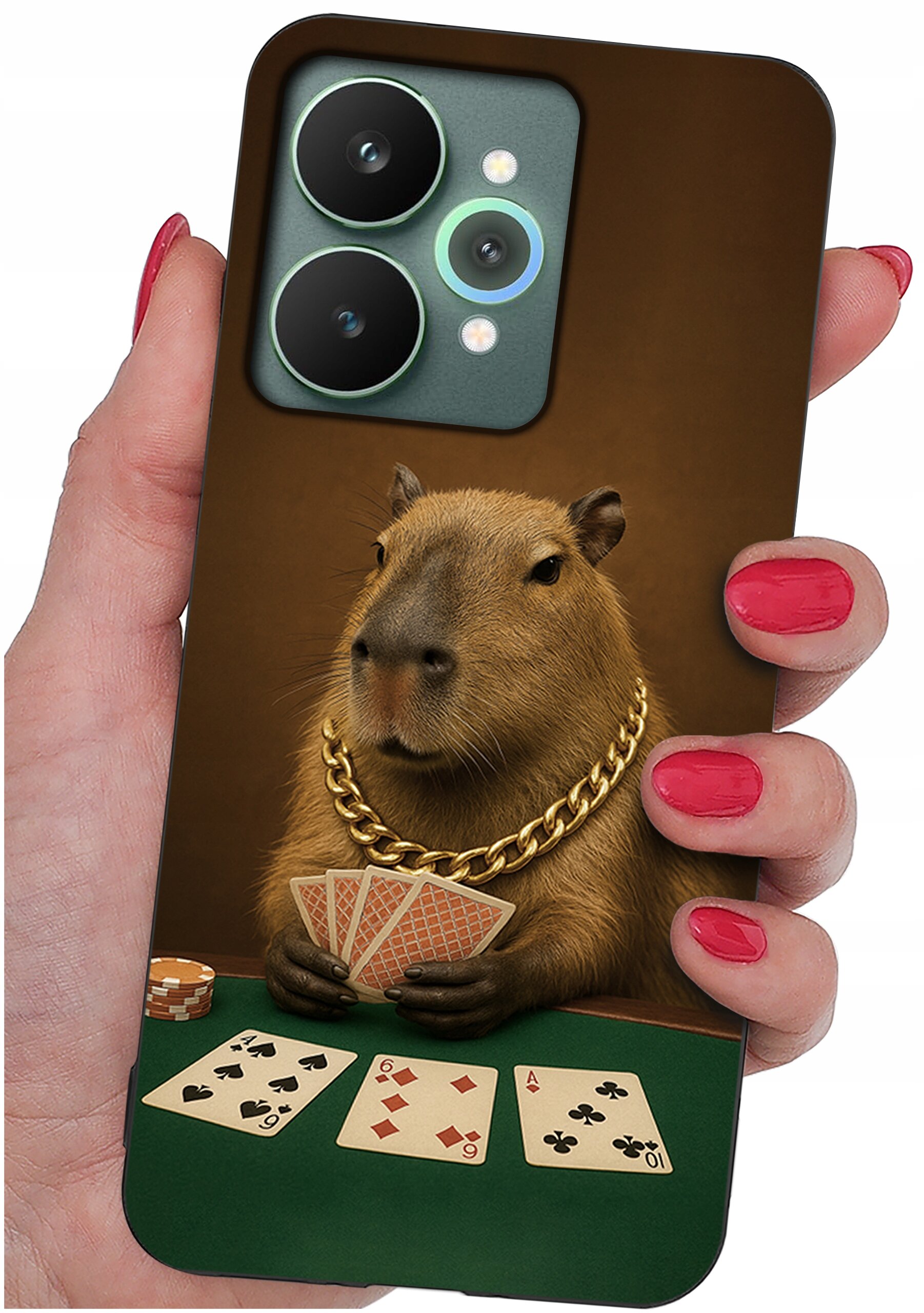 Etui na telefon z nadrukiem kapibary w złotym łańcuchu, trzymającej karty do gry. Na stole leżą trzy odkryte karty i żetony pokerowe.