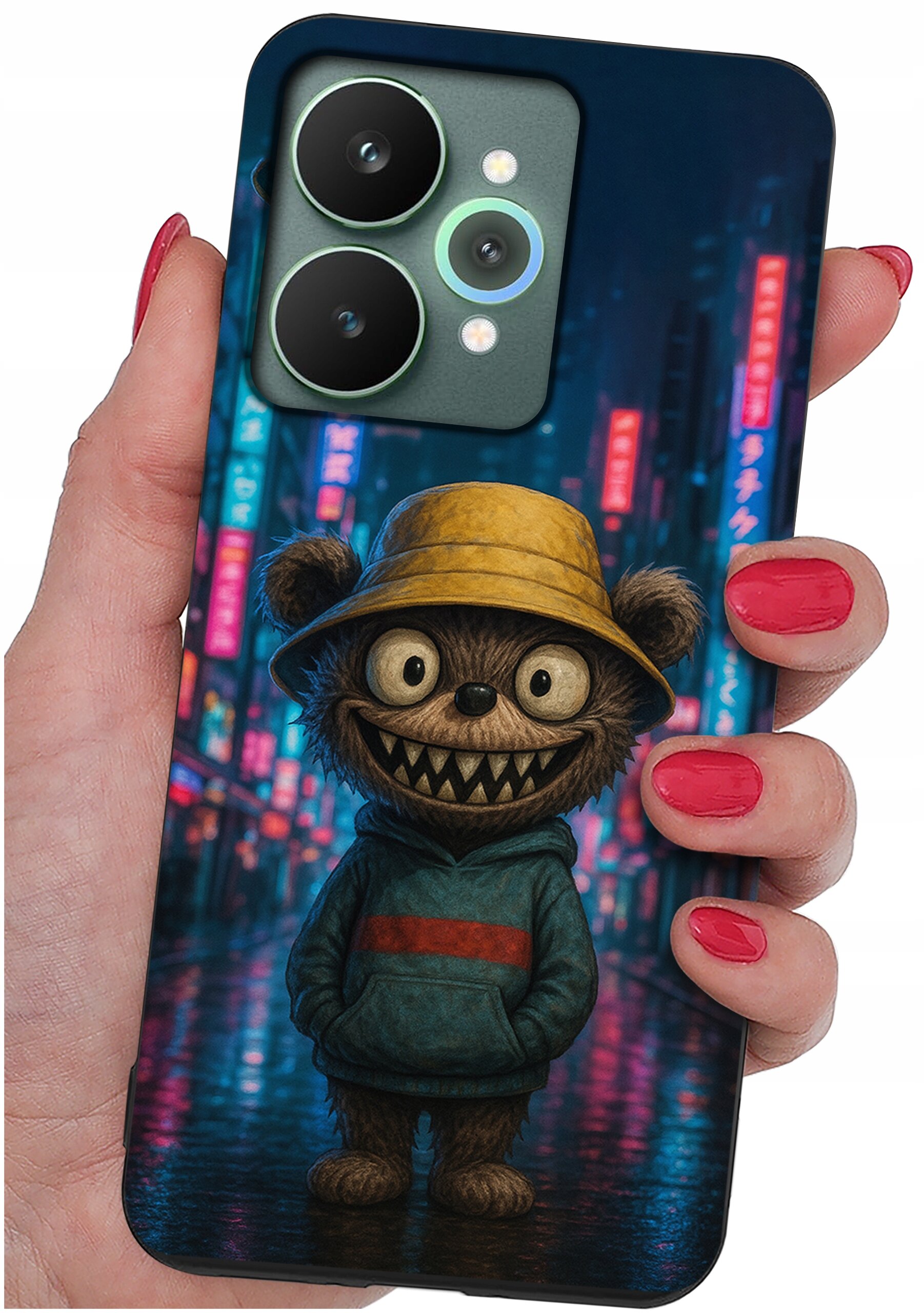 Etui na telefon z nadrukiem postaci przypominającej misia w żółtym kapeluszu i niebieskiej bluzie, trzymane w dłoni z pomalowanymi na czerwono paznokciami. W tle widoczne są rozmyte, kolorowe światła miasta.