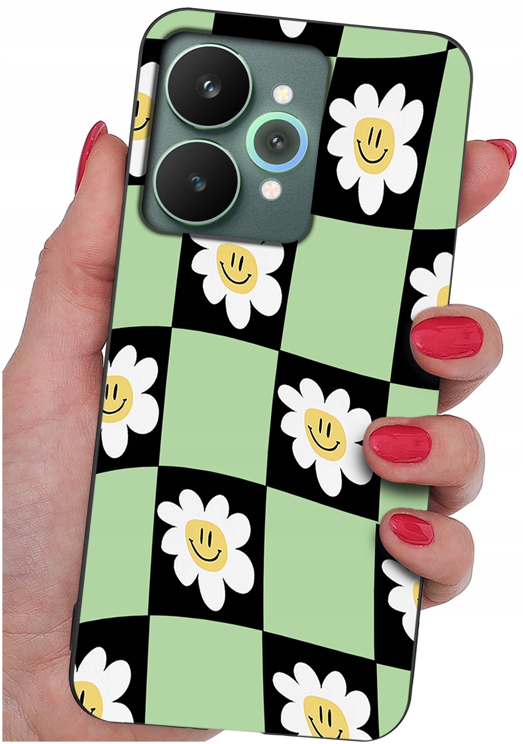 Etui na telefon z wzorem w kratkę, gdzie na czarnych i zielonych polach znajdują się białe kwiaty z uśmiechniętymi buźkami. Etui trzymane jest w dłoni z pomalowanymi na czerwono paznokciami.