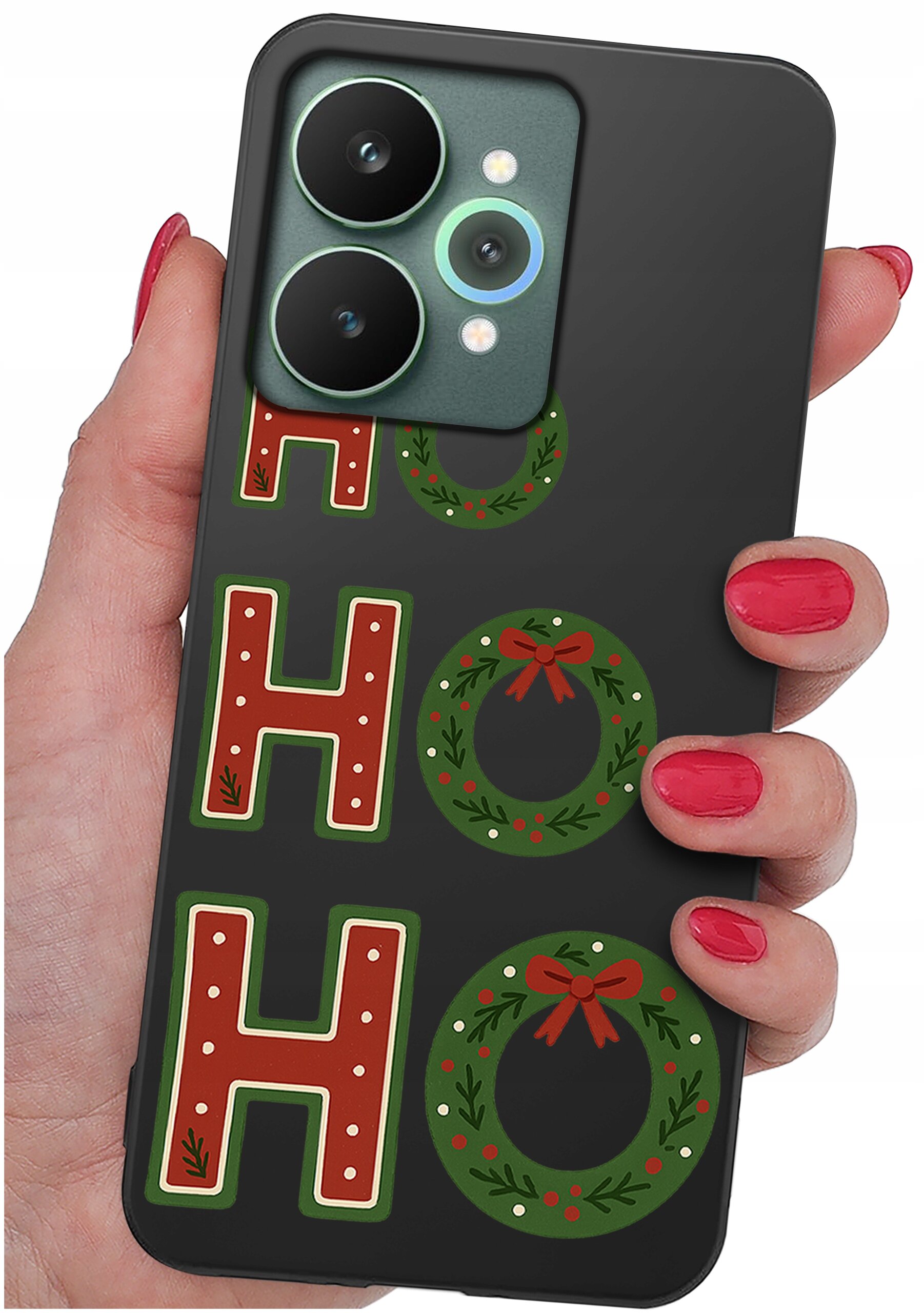 Osoba trzyma telefon z czarnym etui ozdobionym napisem \'HO HO HO\' oraz świątecznymi wieńcami. Paznokcie osoby są pomalowane na czerwono.