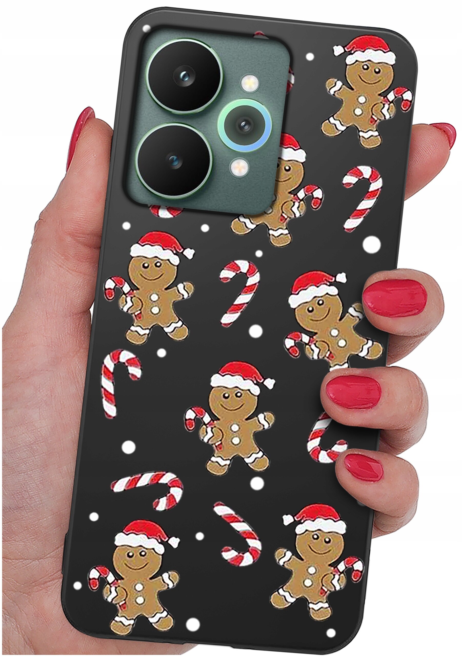Etui na telefon z motywem świątecznym, przedstawiające piernikowe ludziki w czapkach Mikołaja oraz laski cukrowe na czarnym tle. Etui trzymane jest w dłoni z pomalowanymi na czerwono paznokciami.