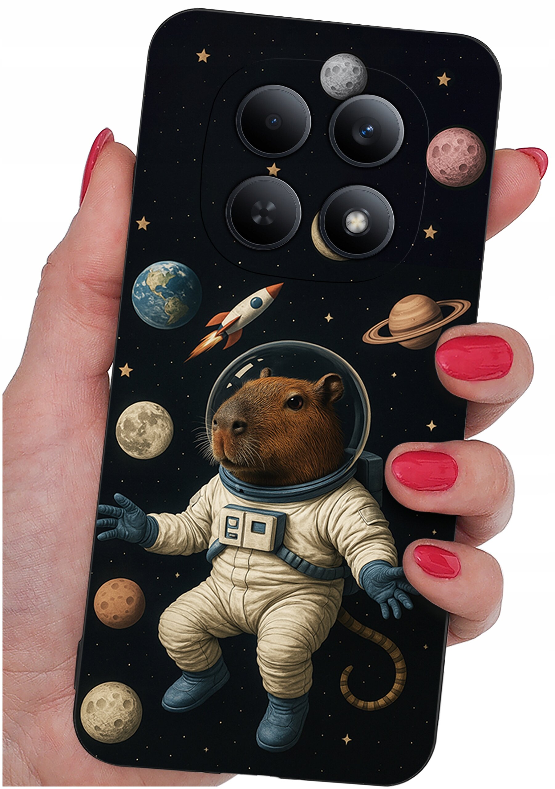 Etui na telefon z motywem kosmicznym, przedstawiające kapibarę w skafandrze astronauty otoczoną planetami i rakietą. Etui trzymane jest w dłoni z pomalowanymi na czerwono paznokciami.