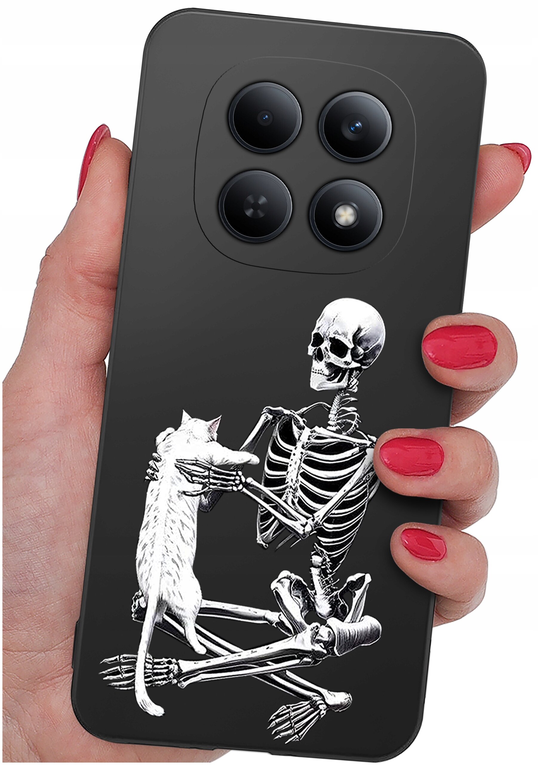 Etui na telefon z czarnym tłem, na którym widoczny jest biały szkielet trzymający kota. Etui jest trzymane w dłoni z pomalowanymi na czerwono paznokciami.
