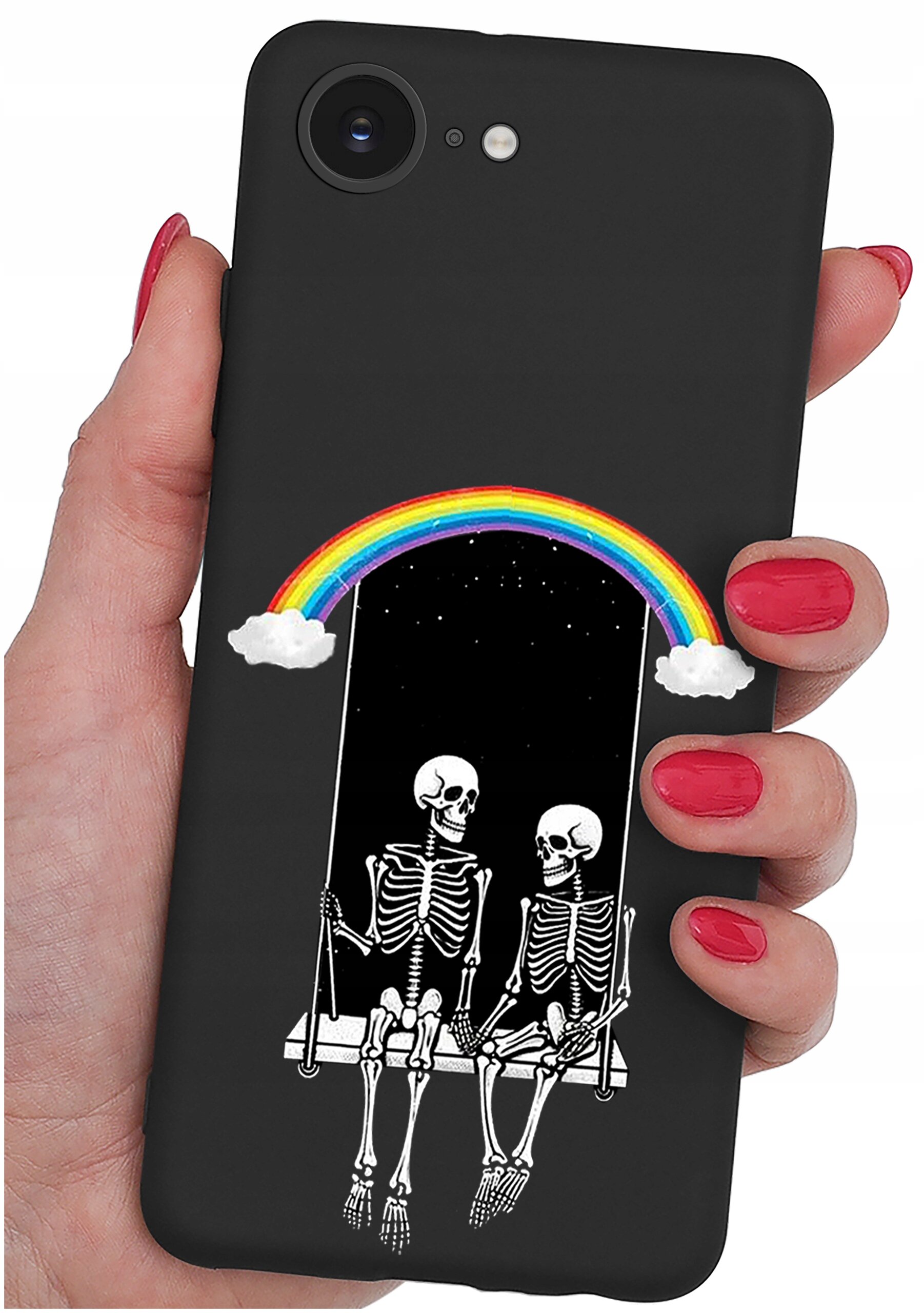 Czarne etui na telefon z grafiką przedstawiającą dwa szkielety siedzące na huśtawce pod tęczą z chmurkami. Etui trzymane jest w dłoni z pomalowanymi na czerwono paznokciami.